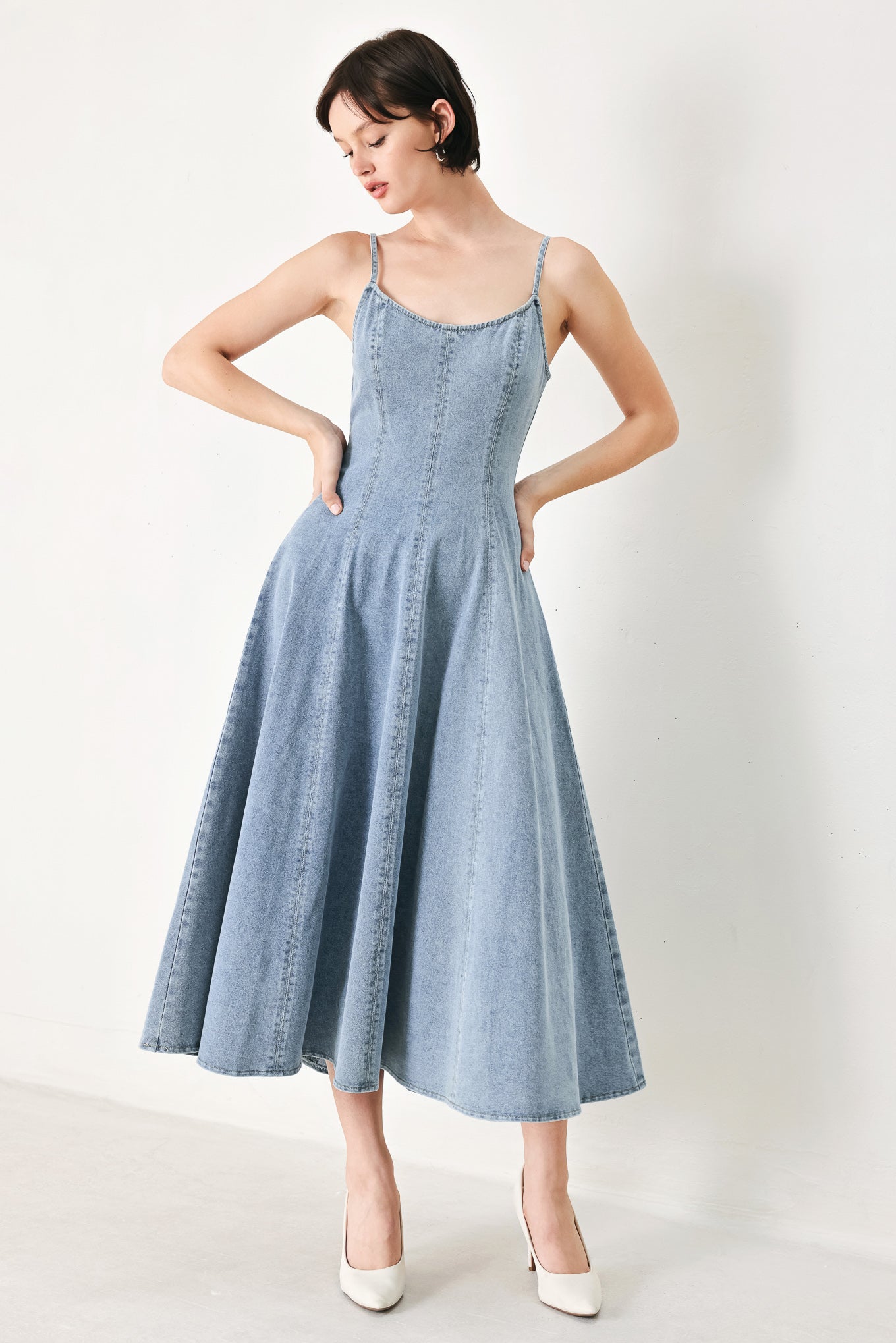 A washed denim midi dress with U neckline, straps, circle skirt and back zipper closure