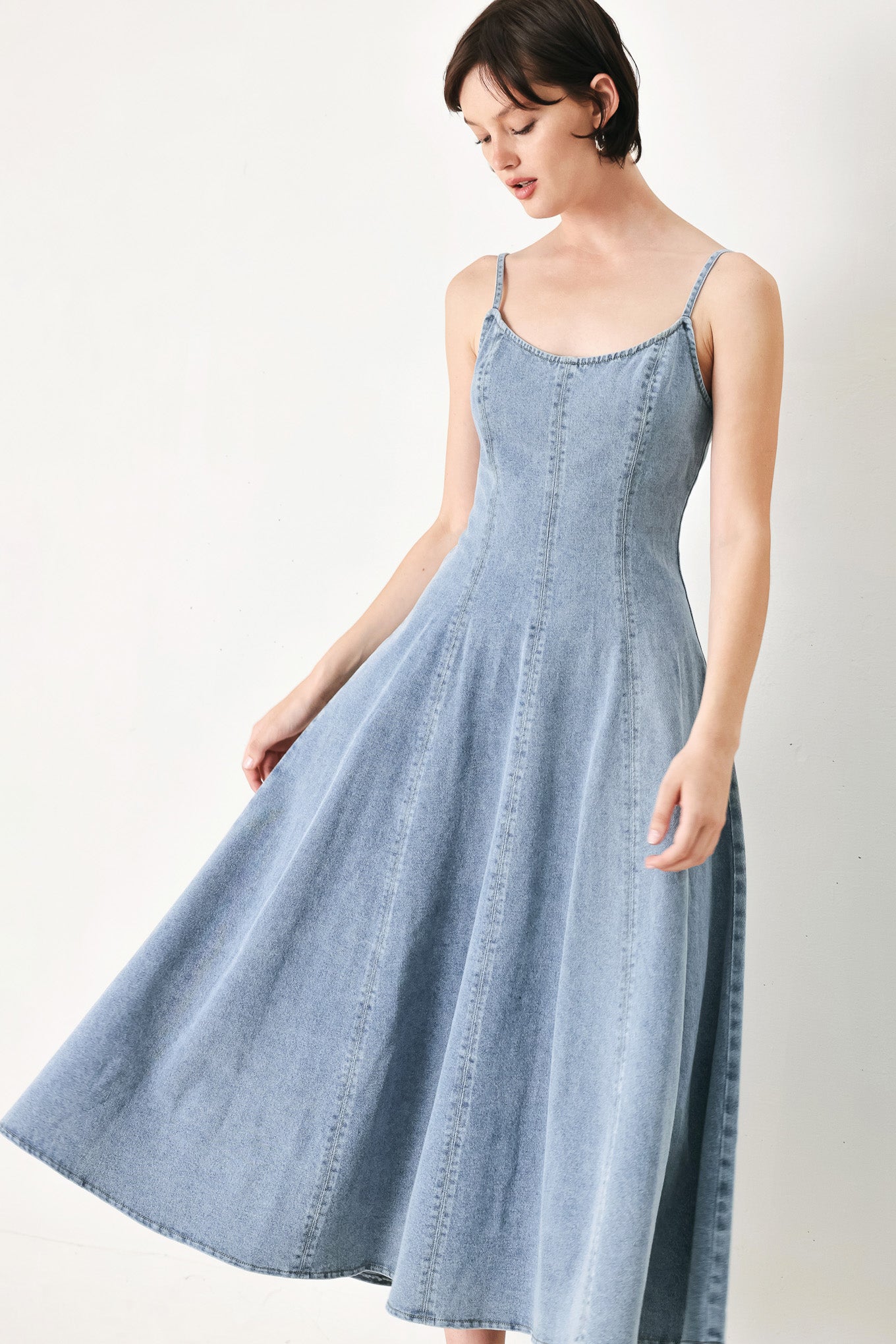 A washed denim midi dress with U neckline, straps, circle skirt and back zipper closure