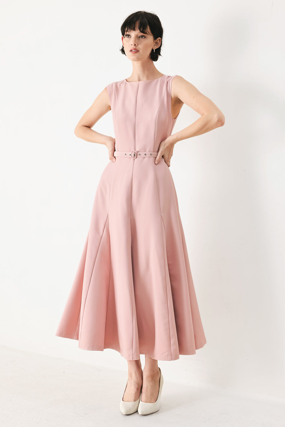 Woman wearing a pink midi dress featuring round neckline, sleeveless, self belt, full circle skirt and back zipper closure | FREEMARKET