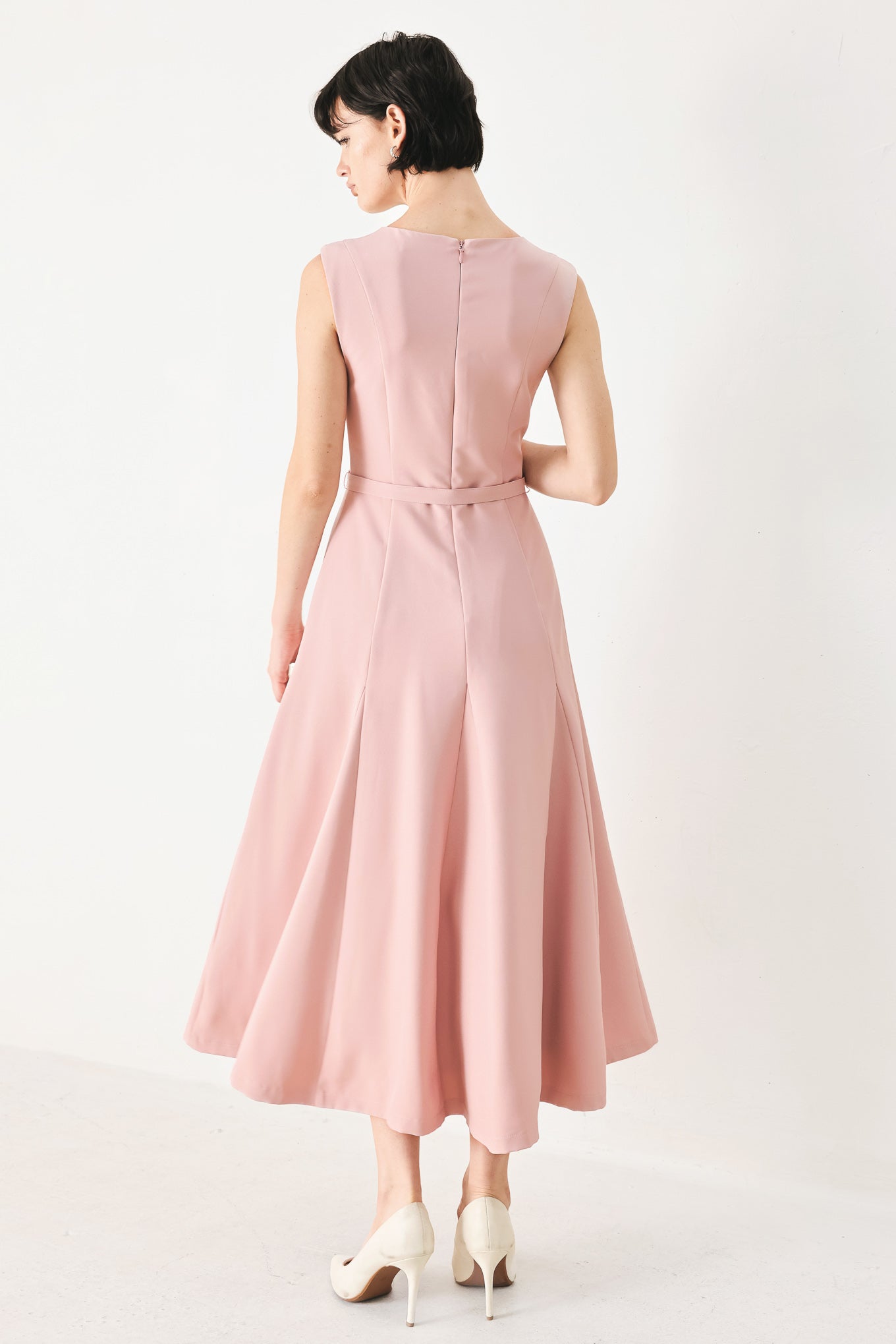 Woman wearing a pink midi dress featuring round neckline, sleeveless, self belt, full circle skirt and back zipper closure | FREEMARKET