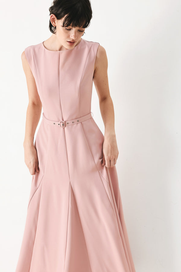 Woman wearing a pink midi dress featuring round neckline, sleeveless, self belt, full circle skirt and back zipper closure | FREEMARKET