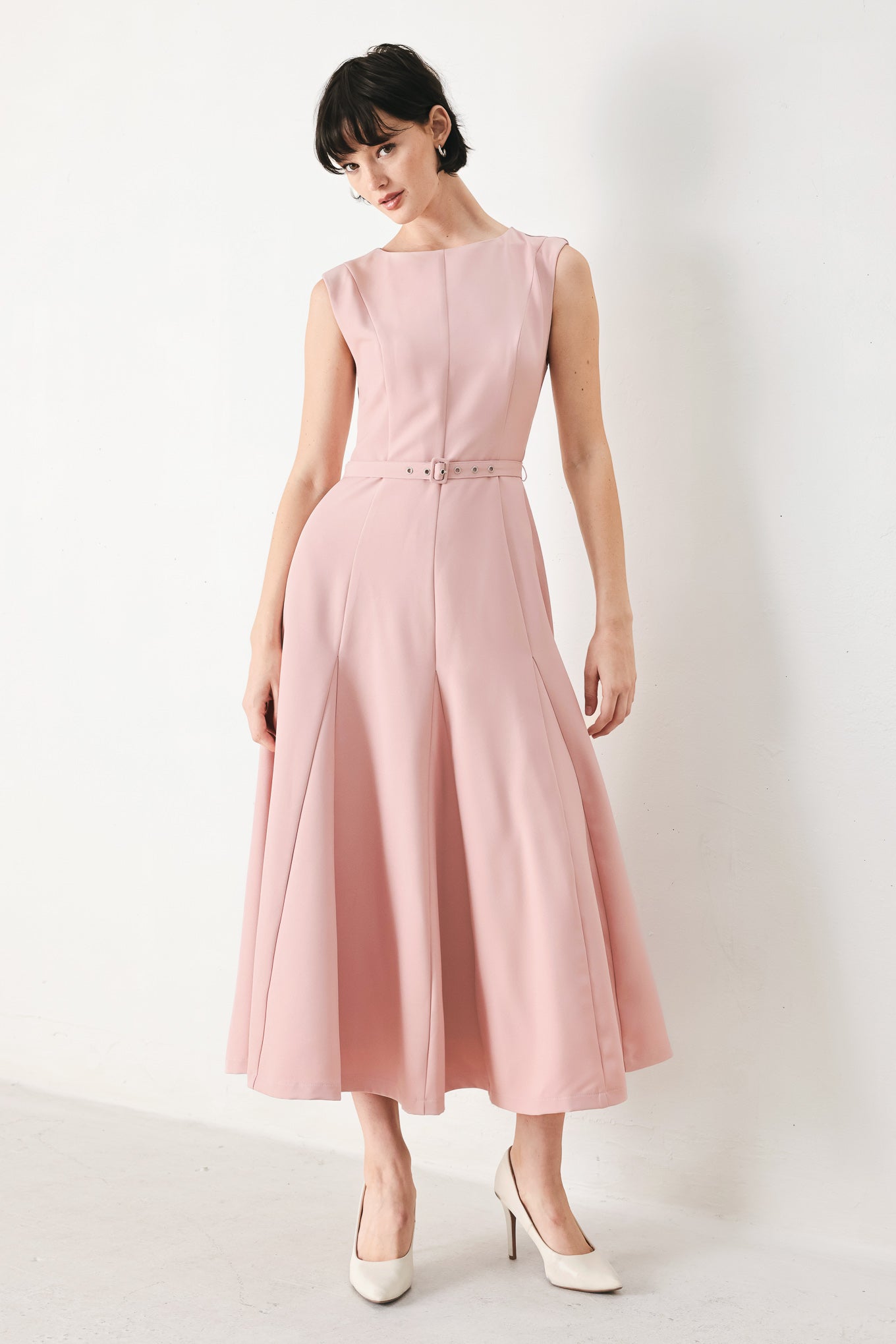 Woman wearing a pink midi dress featuring round neckline, sleeveless, self belt, full circle skirt and back zipper closure | FREEMARKET