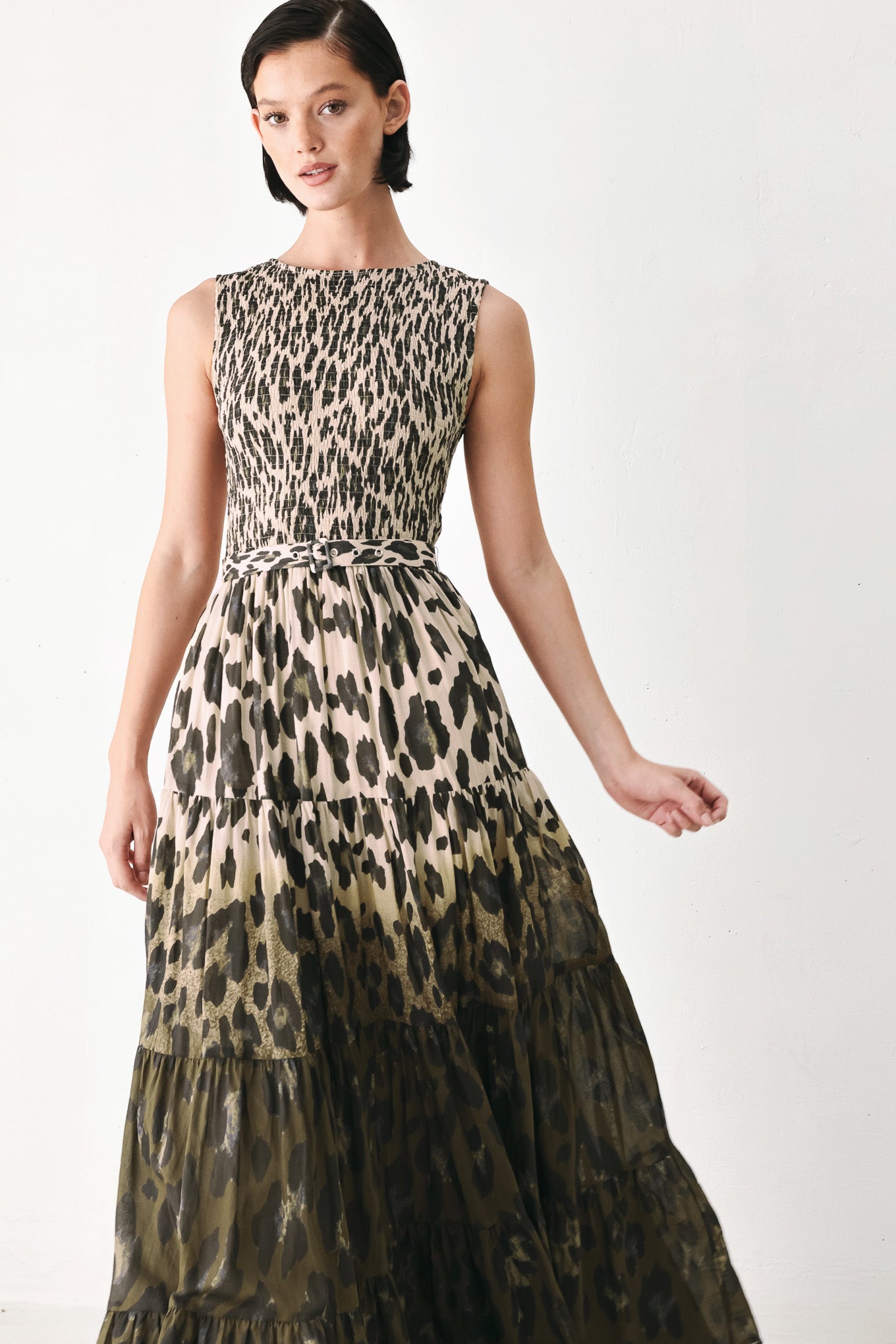A woman modeling a sleeveless tiered maxi dress with an abstract leopard print in beige & brown | FREEMARKET