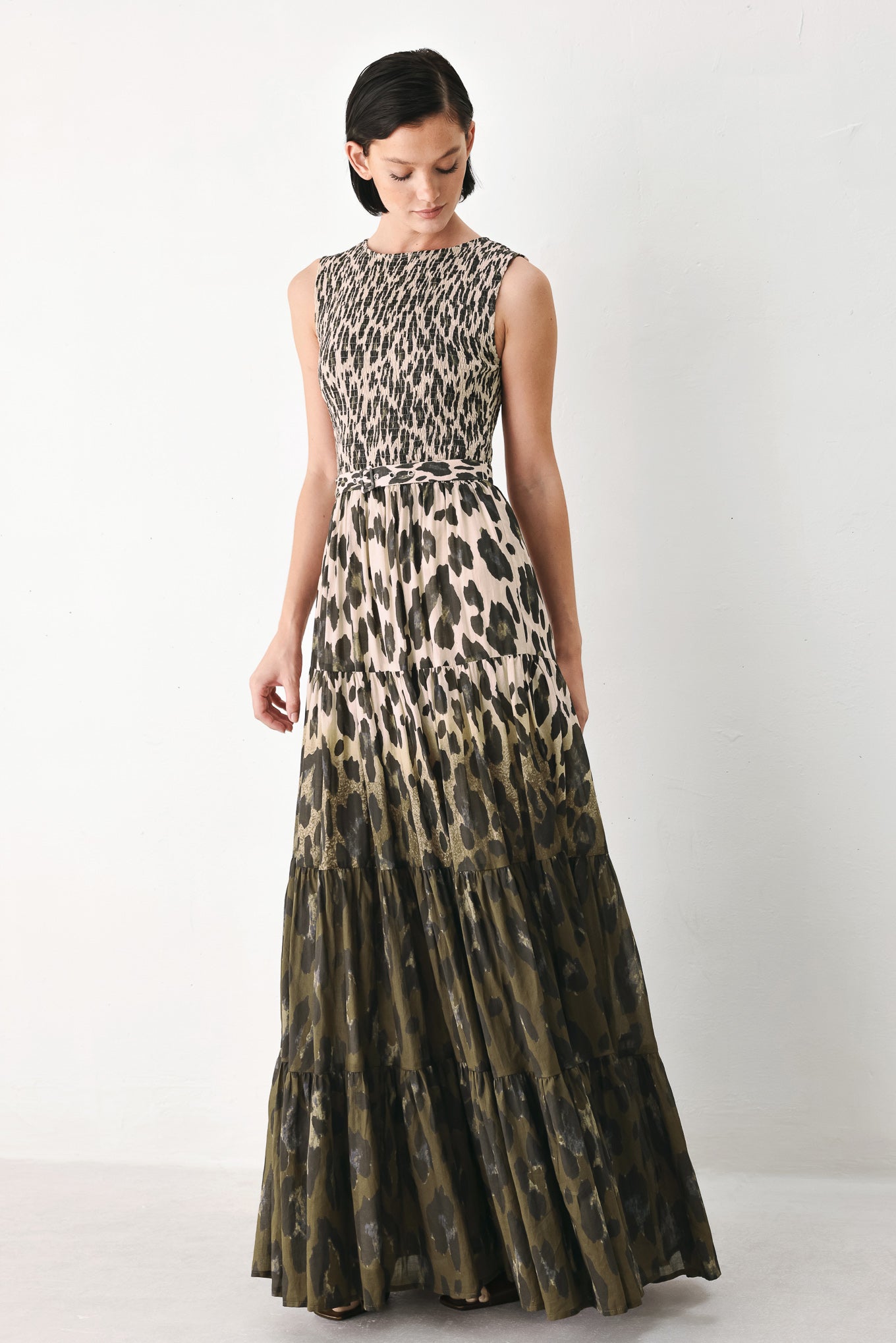 A woman modeling a sleeveless tiered maxi dress with an abstract leopard print in beige & brown | FREEMARKET