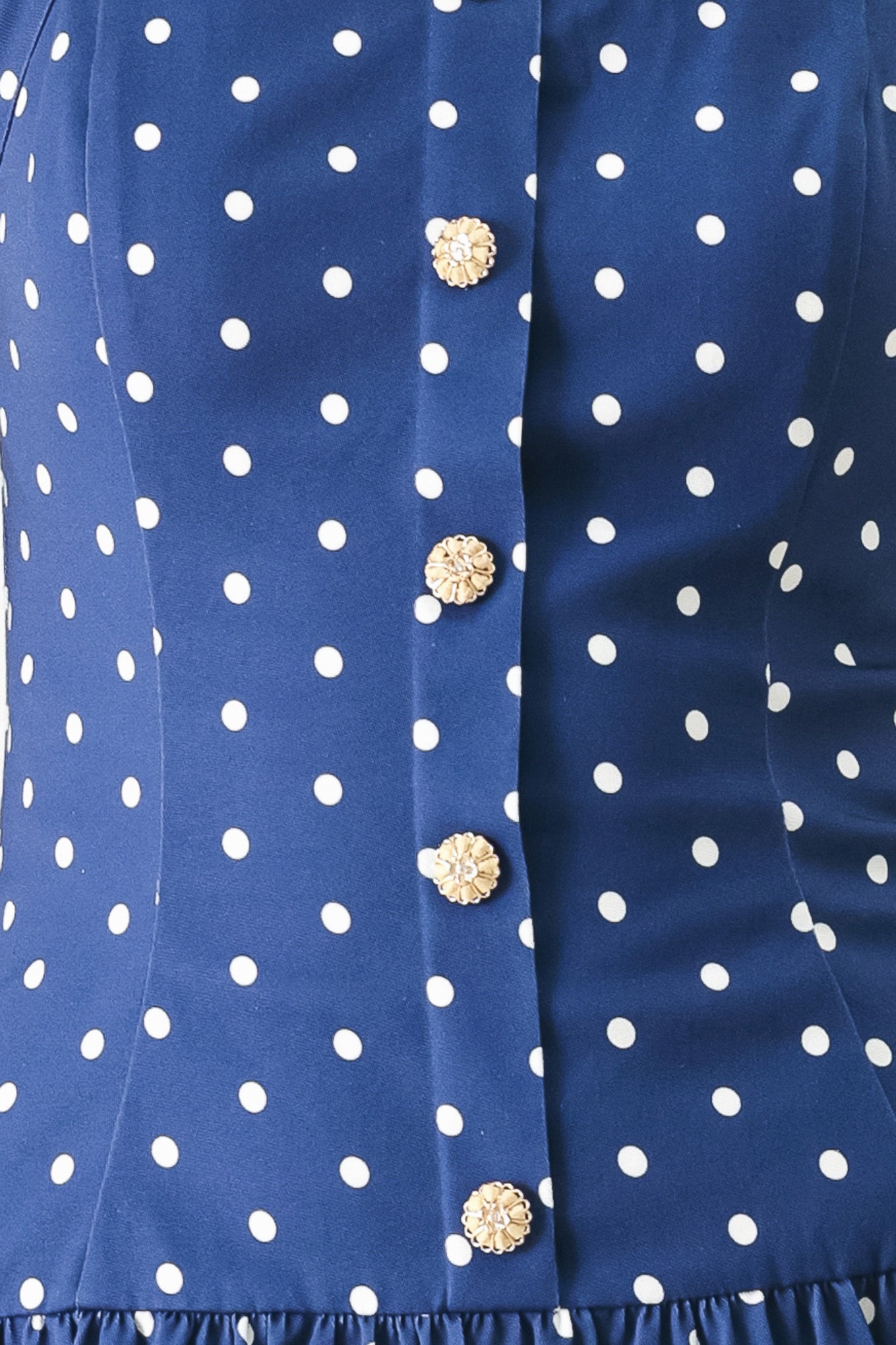 Close up of a blue polka dot mini dress featuring straight neckline with halter strap, drop waist and bare back with smocking zipper closure | FREEMARKET