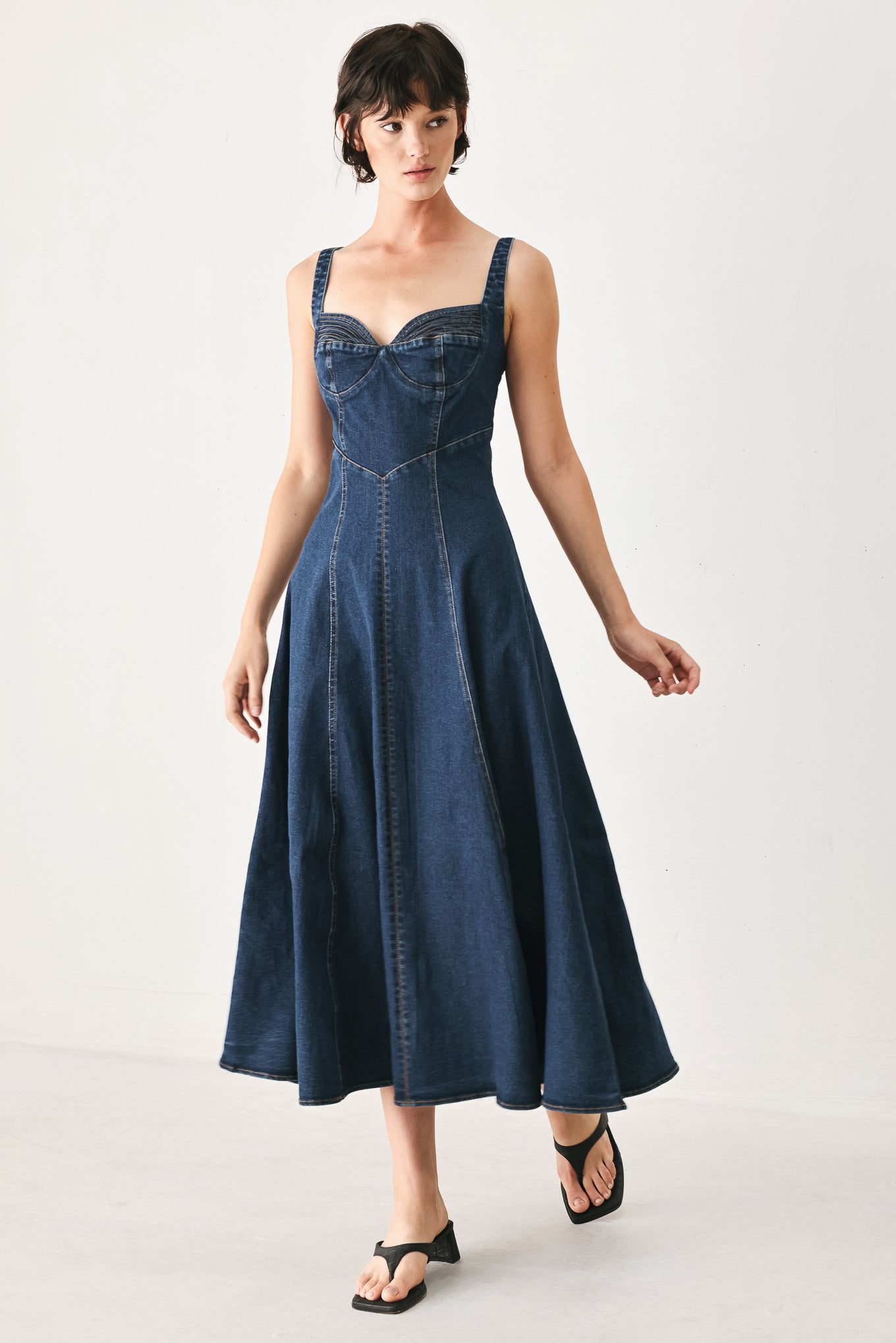 Woman wearing a blue indigo denim midi dress featuring sweetheart neckline, straps, circle skirt and back zipper closure | FREEMARKET