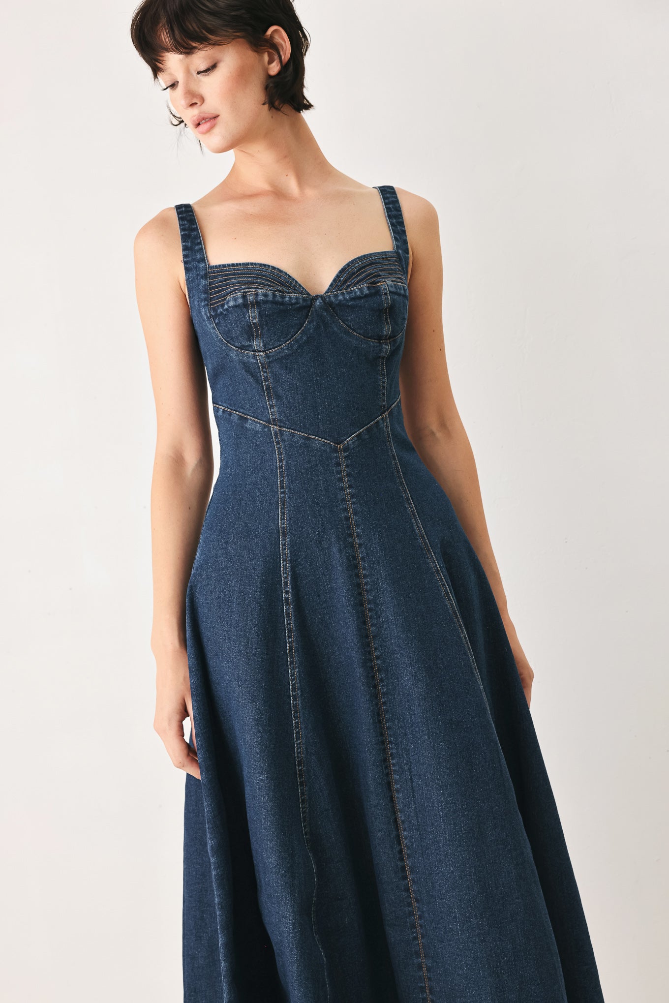 Woman wearing a blue indigo denim midi dress featuring sweetheart neckline, straps, circle skirt and back zipper closure | FREEMARKET