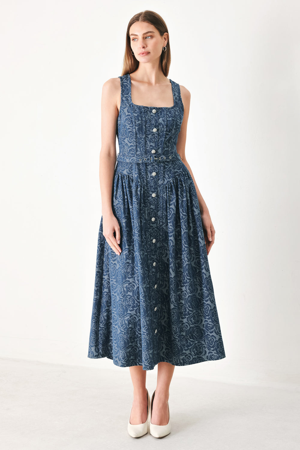 Woman wearing a blue patterned jacquard denim midi dress featuring square neckline, sleeveless, button down detail, self belt, basque waistline, full skirt and back zipper closure | FREEMARKET | Flying Tomato