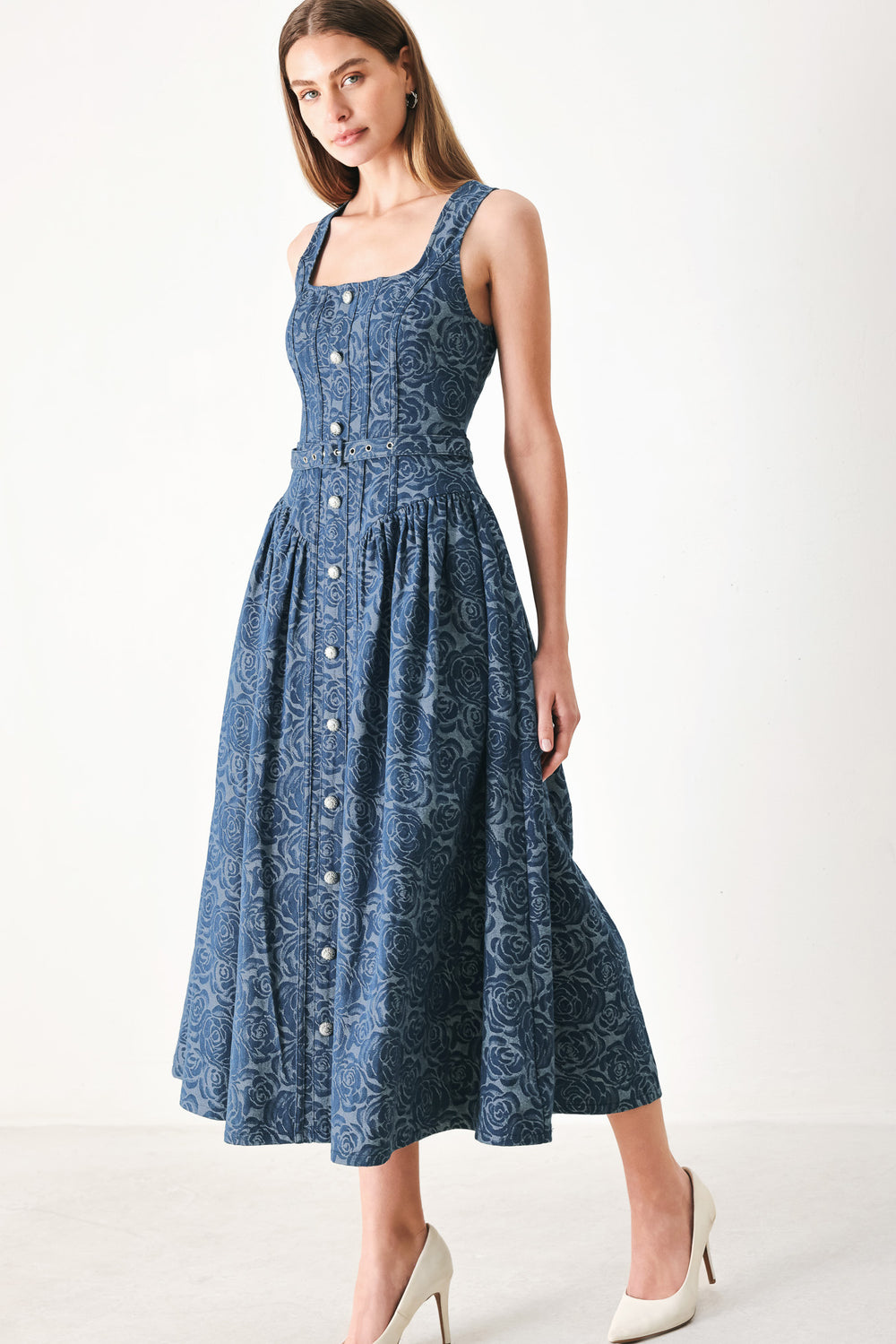 Woman wearing a blue patterned jacquard denim midi dress featuring square neckline, sleeveless, button down detail, self belt, basque waistline, full skirt and back zipper closure | FREEMARKET | Flying Tomato