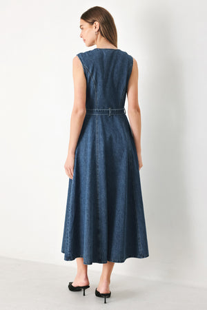 Woman wearing a blue denim midi dress featuring round neckline, sleeveless, self sash tie, circle skirt, side pockets and front zipper closure | FREEMARKET | Flying Tomato