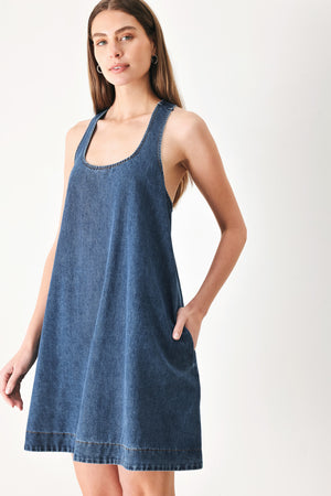 Woman wearing a blue denim mini dress with halter neckline and racer back and buckle | FREEMARKET | Flying Tomato