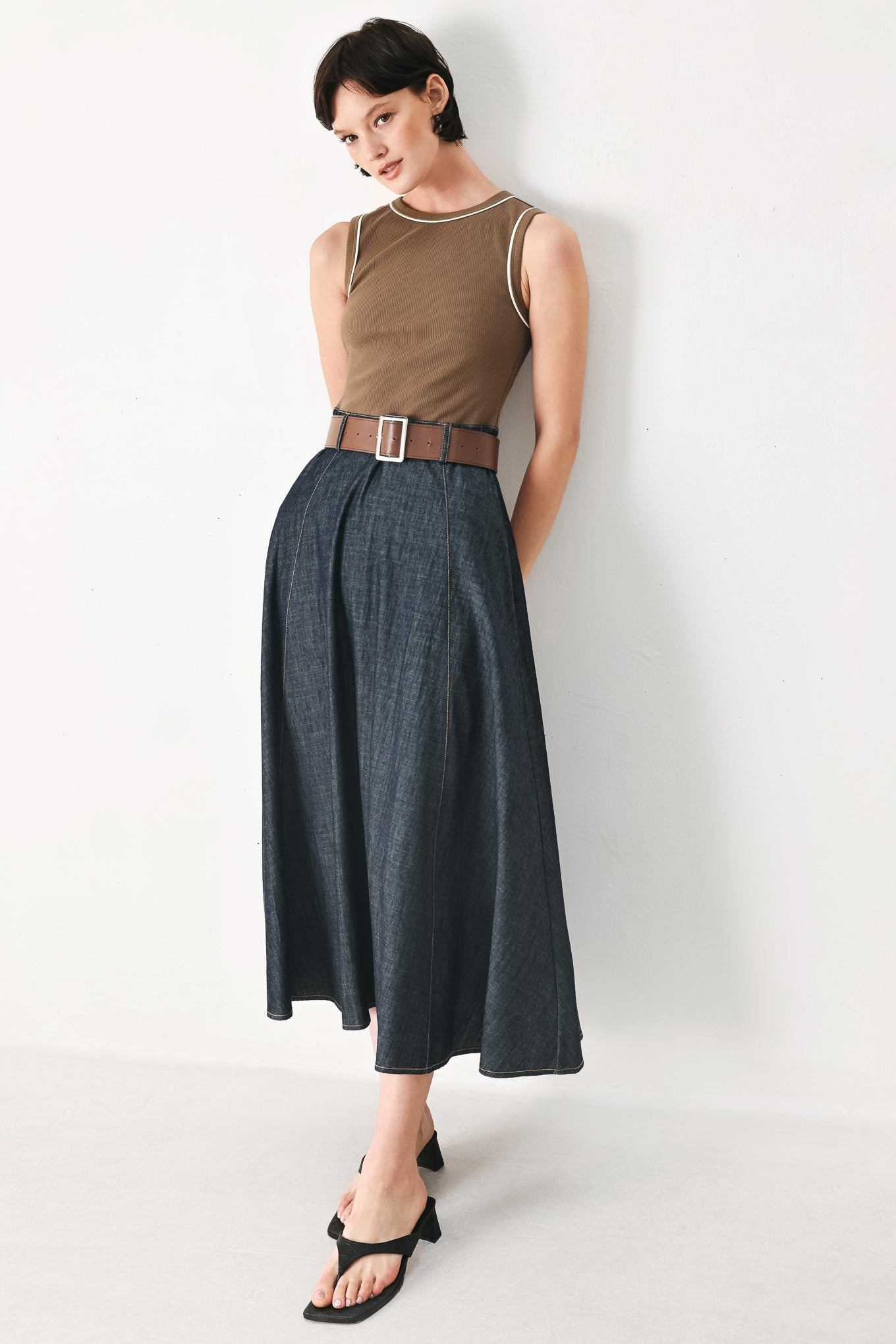Woman wearing a sleeveless midi dress with a brown knit top and dark denim combination with a contrasting belt and back zipper closure | FREEMARKET
