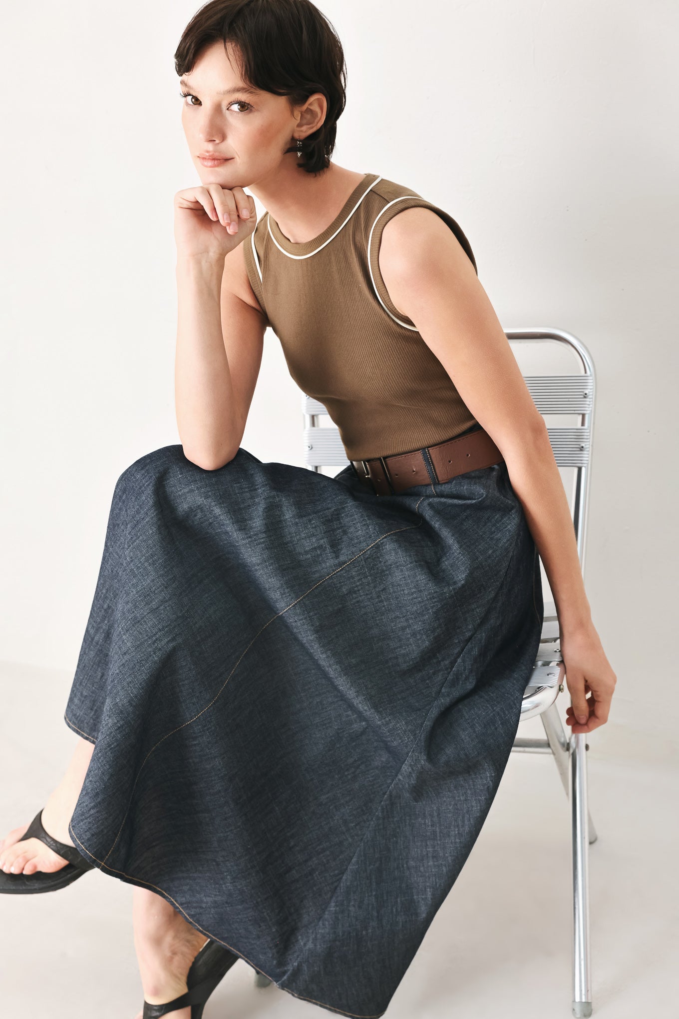 Woman wearing a sleeveless midi dress with a brown knit top and dark denim combination with a contrasting belt and back zipper closure | FREEMARKET