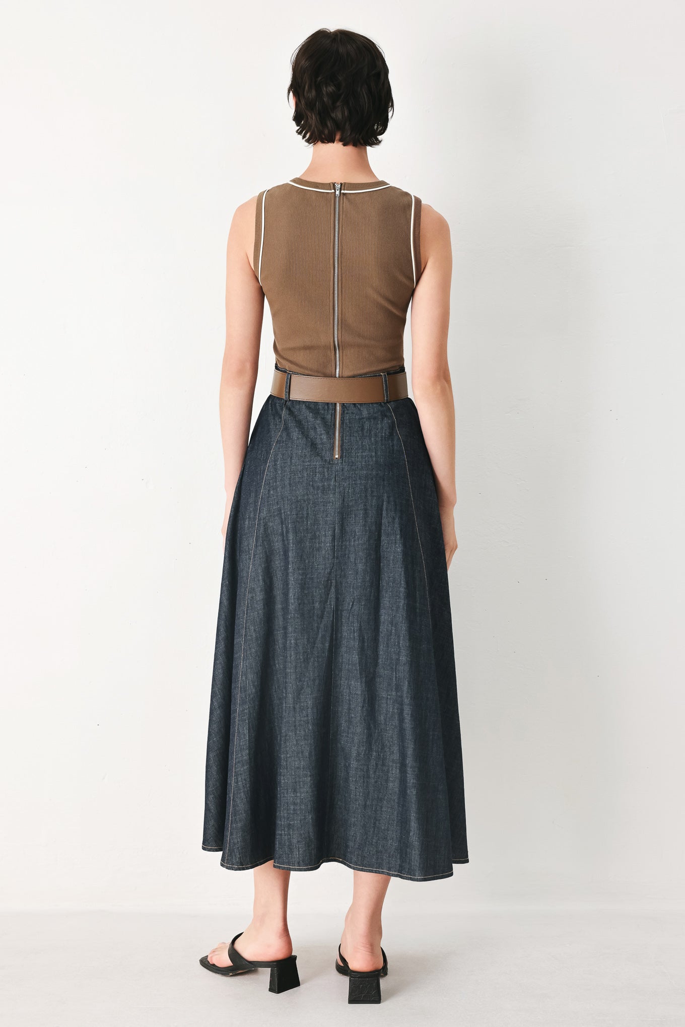 Woman wearing a sleeveless midi dress with a brown knit top and dark denim combination with a contrasting belt and back zipper closure | FREEMARKET