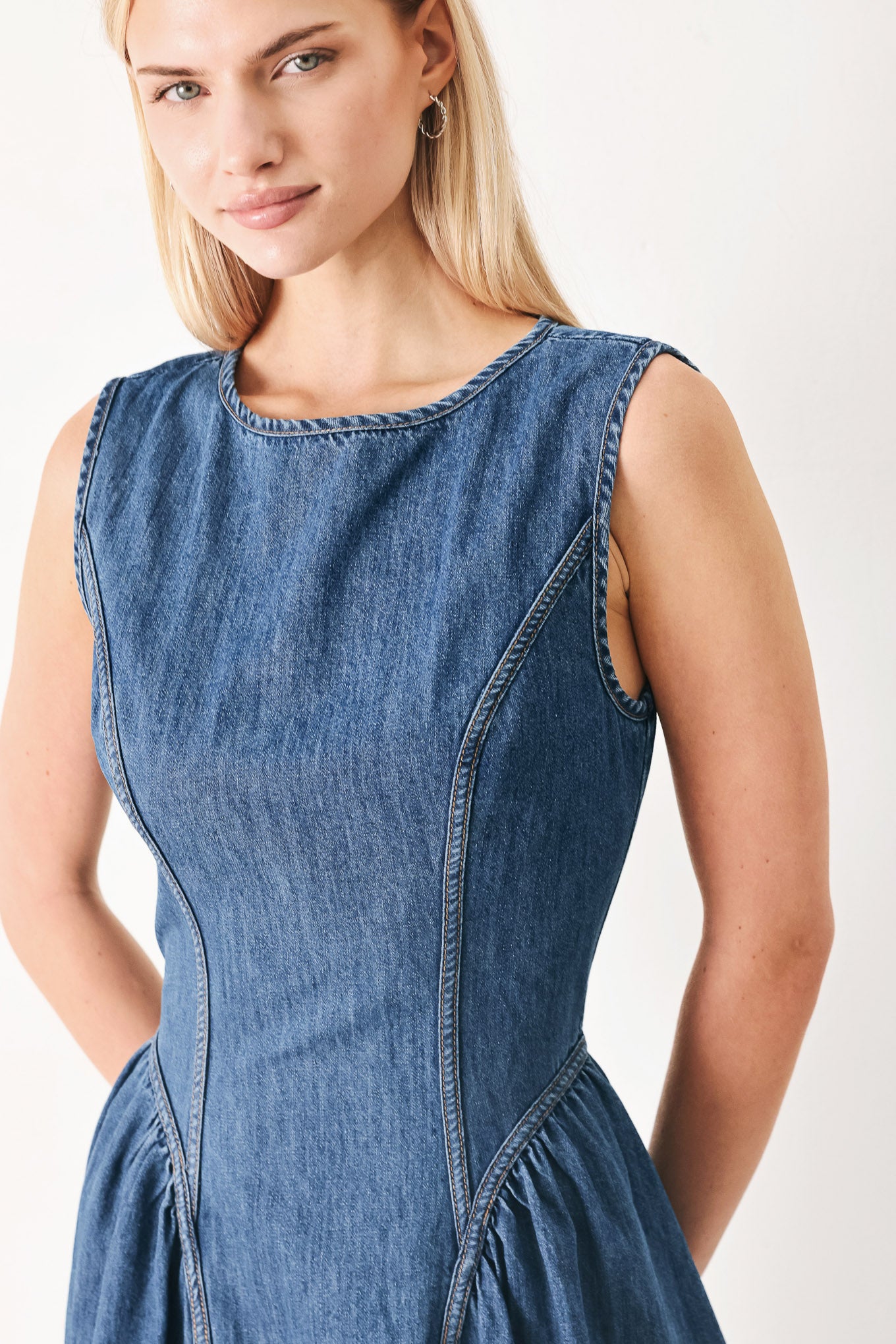 Woman wearing a blue denim midi dress featuring round neckline, sleeveless, side shirred full skirt and back zipper closure | FREEMARKET