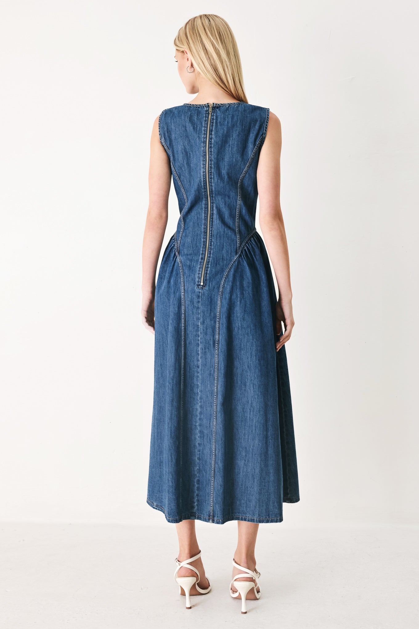 Woman wearing a blue denim midi dress featuring round neckline, sleeveless, side shirred full skirt and back zipper closure | FREEMARKET