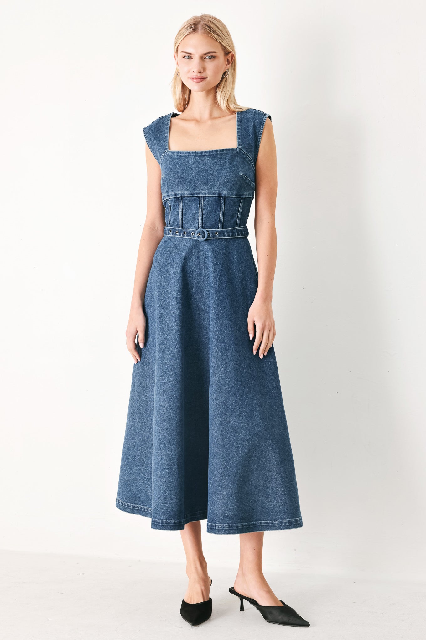 Woman wearing a blue denim midi dress featuring square neckline, corset waist, self belt, side pockets and back zipper closure | FREEMARKET
