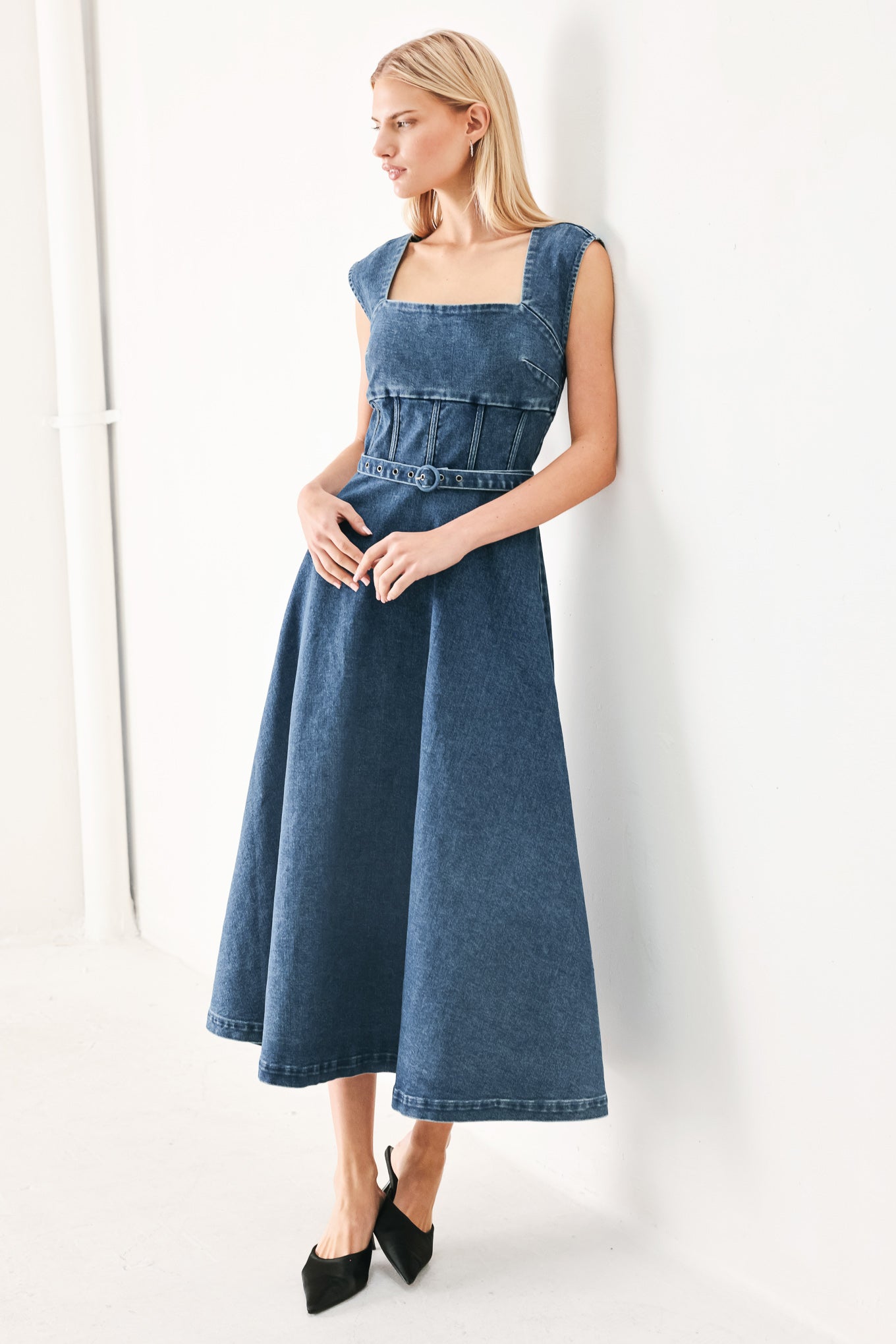 Woman wearing a blue denim midi dress featuring square neckline, corset waist, self belt, side pockets and back zipper closure | FREEMARKET
