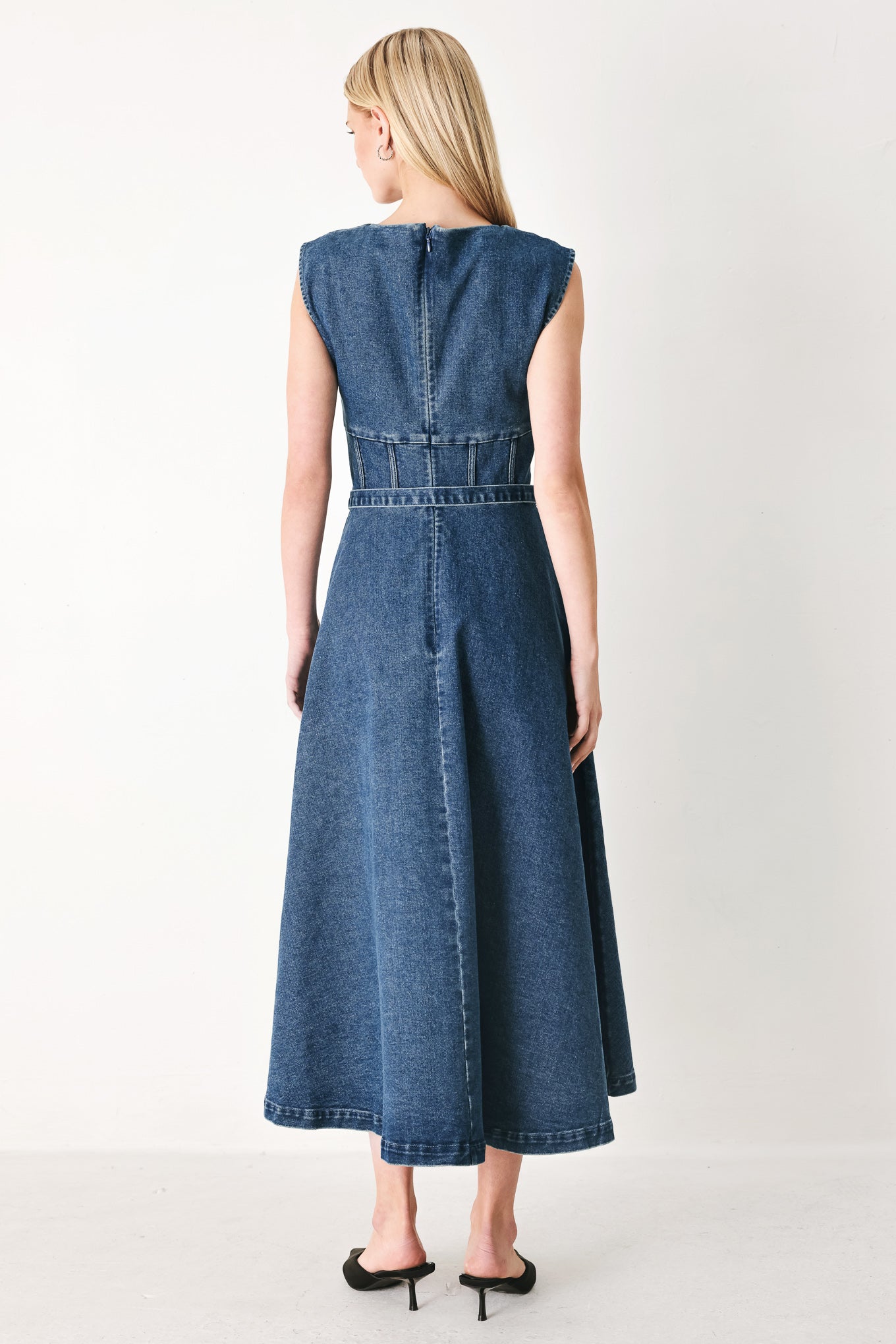 Woman wearing a blue denim midi dress featuring square neckline, corset waist, self belt, side pockets and back zipper closure | FREEMARKET
