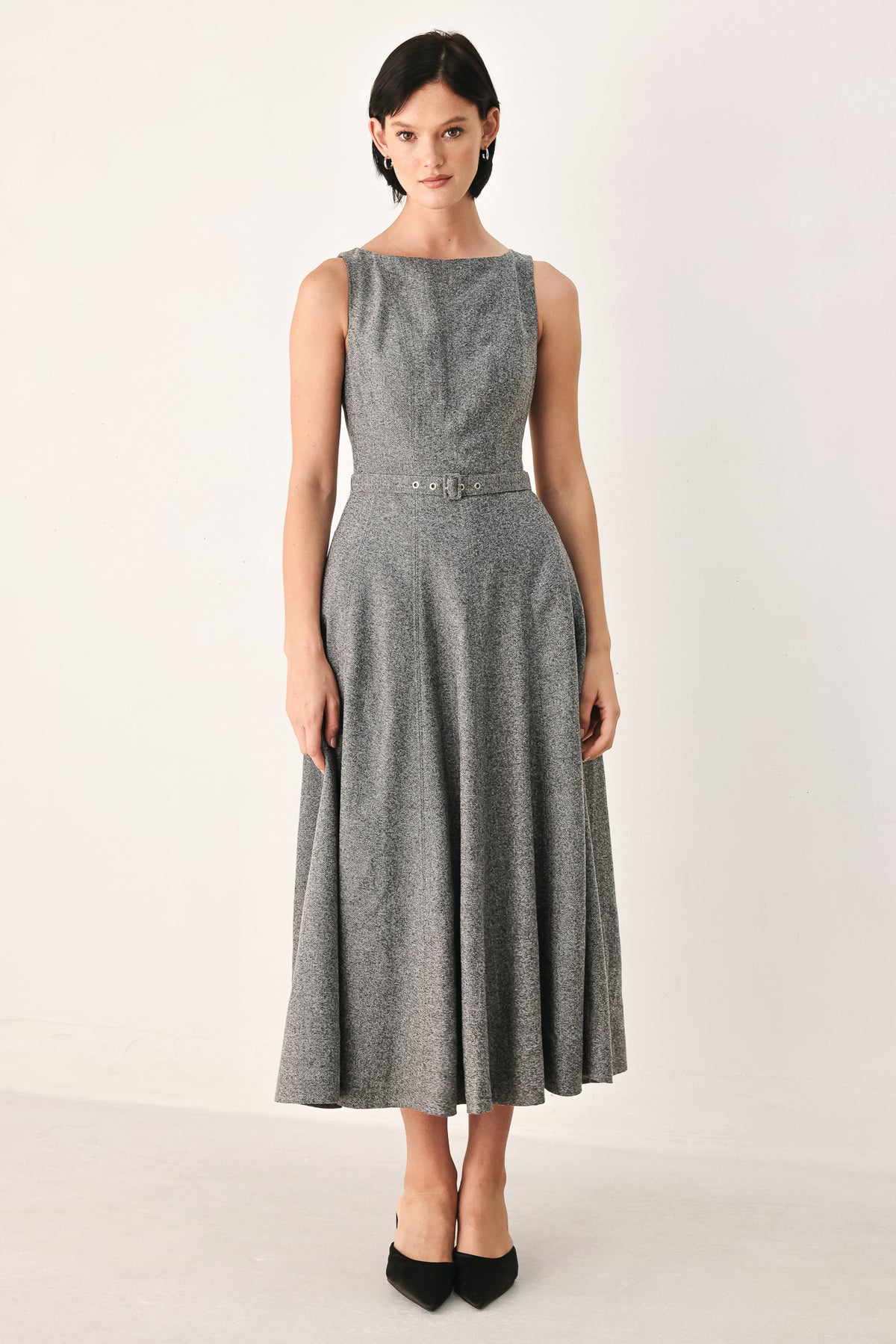 A woman modeling a sleeveless gray midi dress with a structured bodice, defined waist, and flared skirt | FREEMARKET