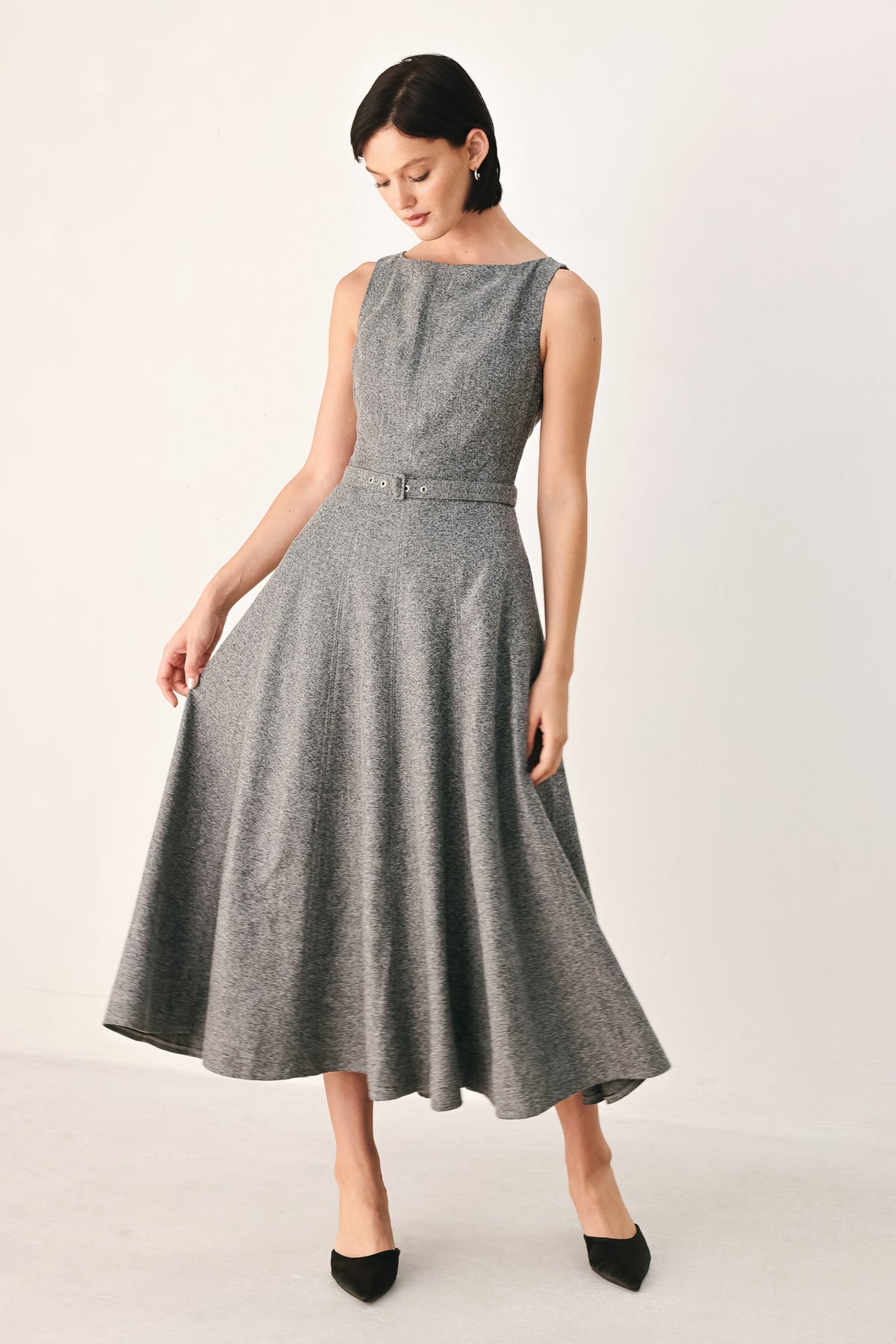 A woman modeling a sleeveless gray midi dress with a structured bodice, defined waist, and flared skirt | FREEMARKET