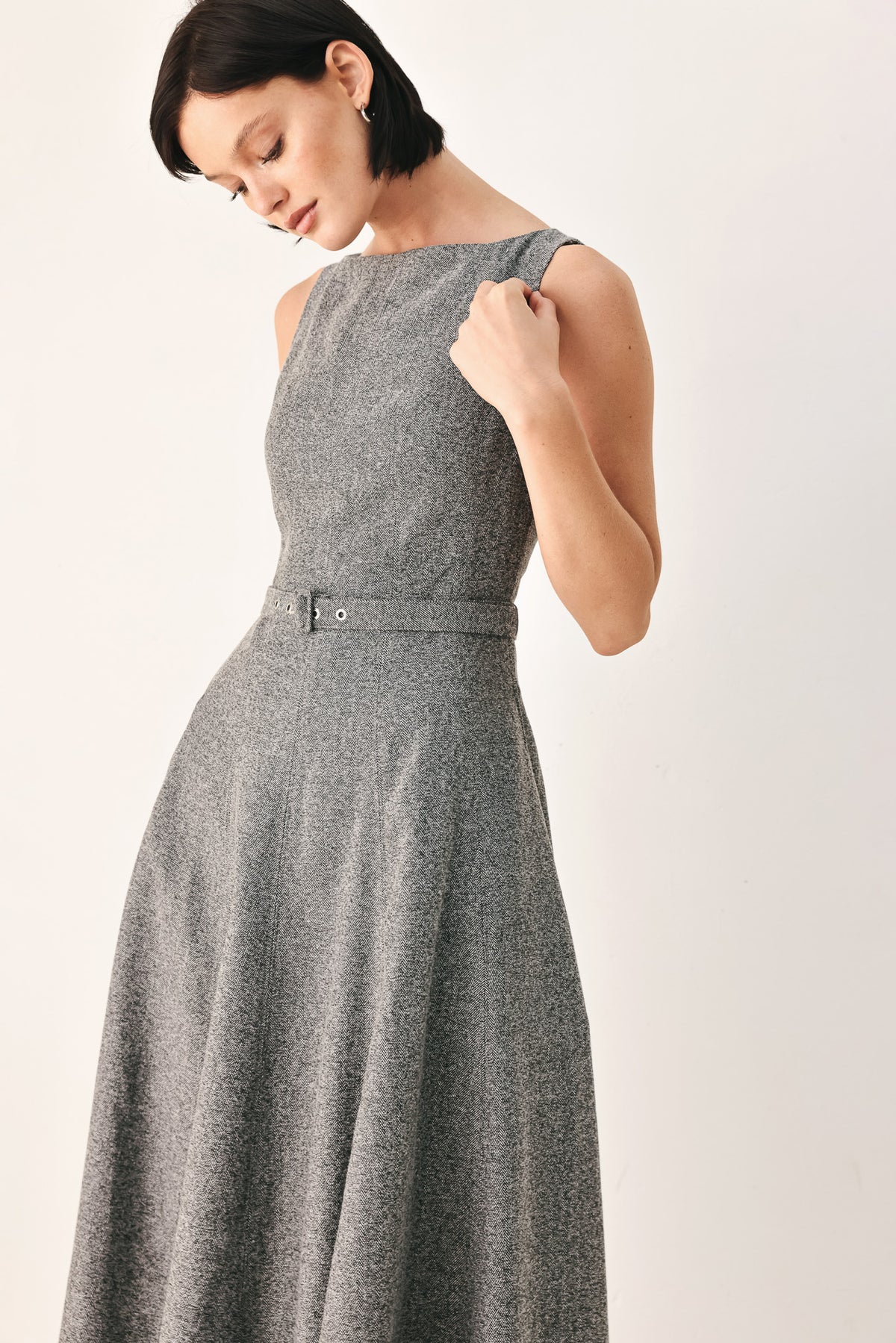 A woman modeling a sleeveless gray midi dress with a structured bodice, defined waist, and flared skirt | FREEMARKET