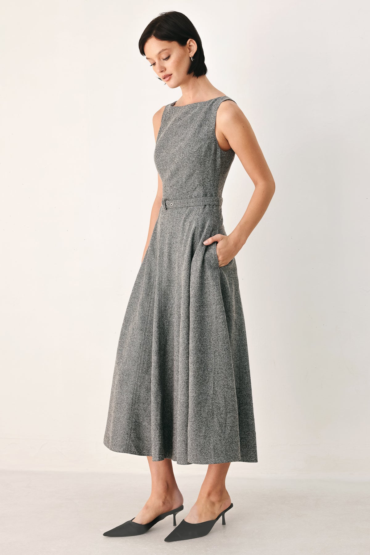 A woman modeling a sleeveless gray midi dress with a structured bodice, defined waist, and flared skirt | FREEMARKET