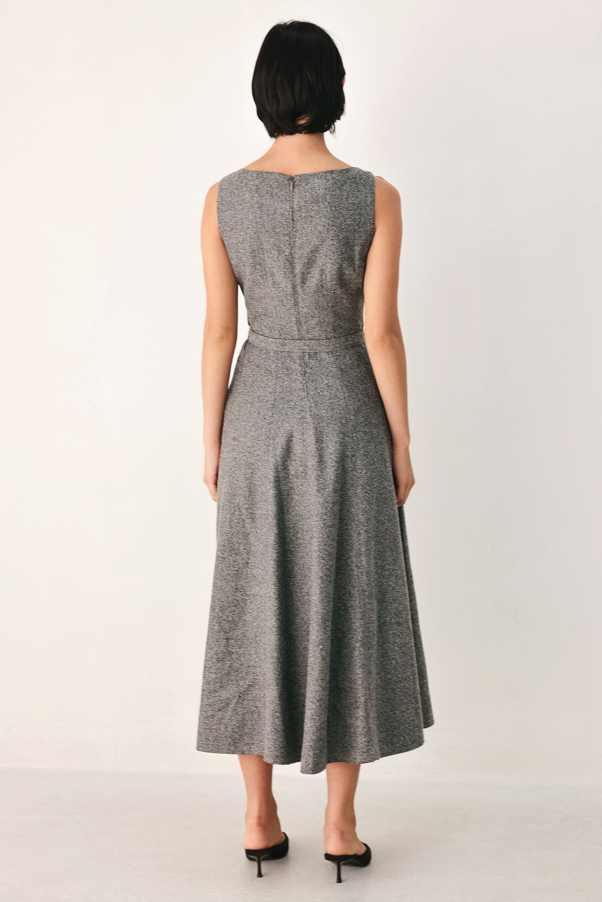 A woman modeling a sleeveless gray midi dress with a structured bodice, defined waist, and flared skirt | FREEMARKET