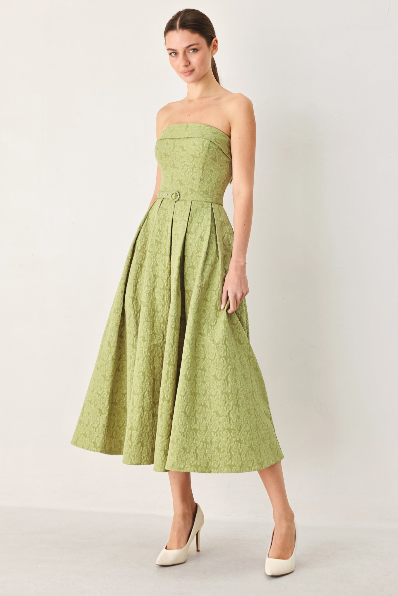 A woman modeling a strapless midi dress in a light olive color with a textured jacquard pattern | FREEMARKET