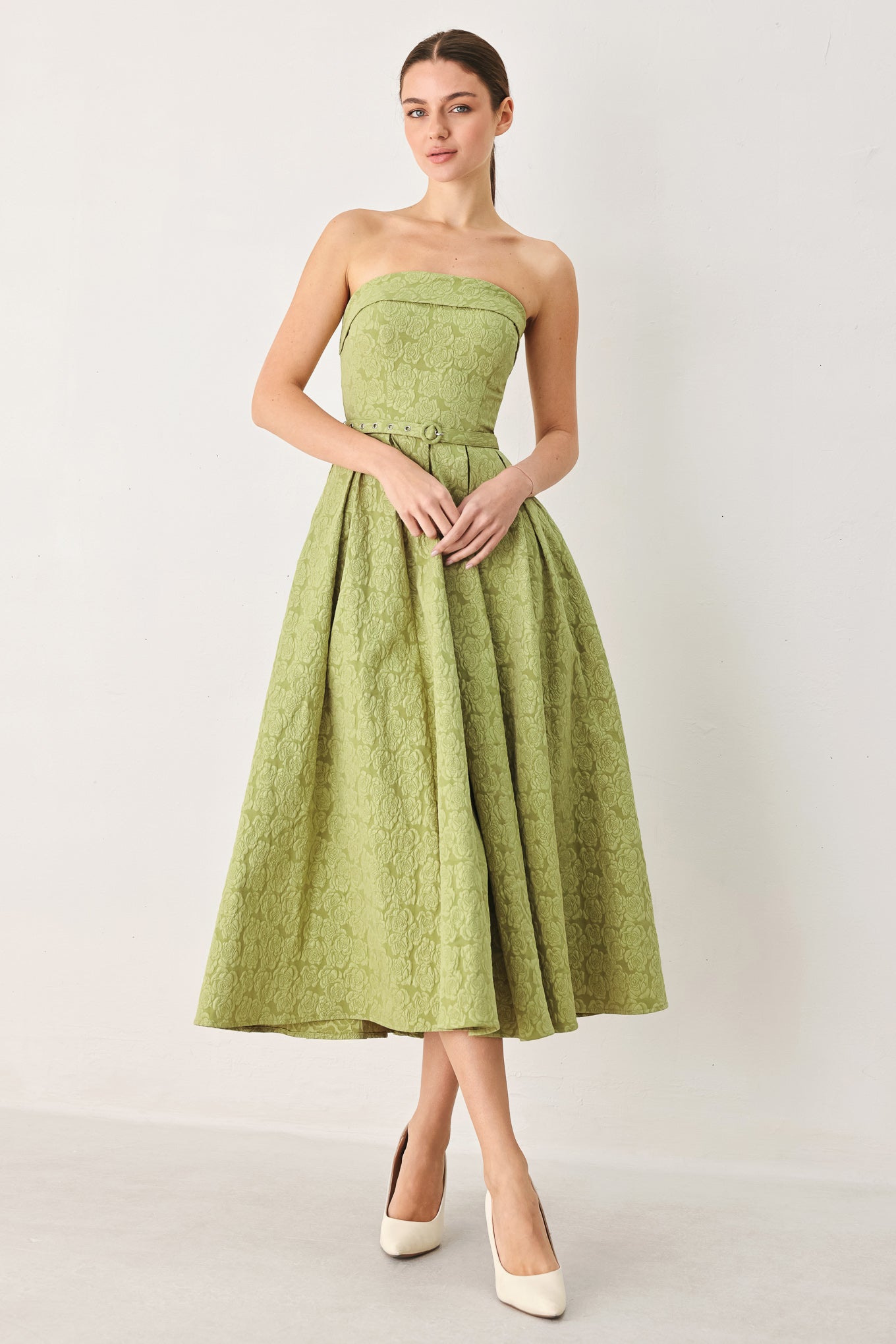 A woman modeling a strapless midi dress in a light olive color with a textured jacquard pattern | FREEMARKET