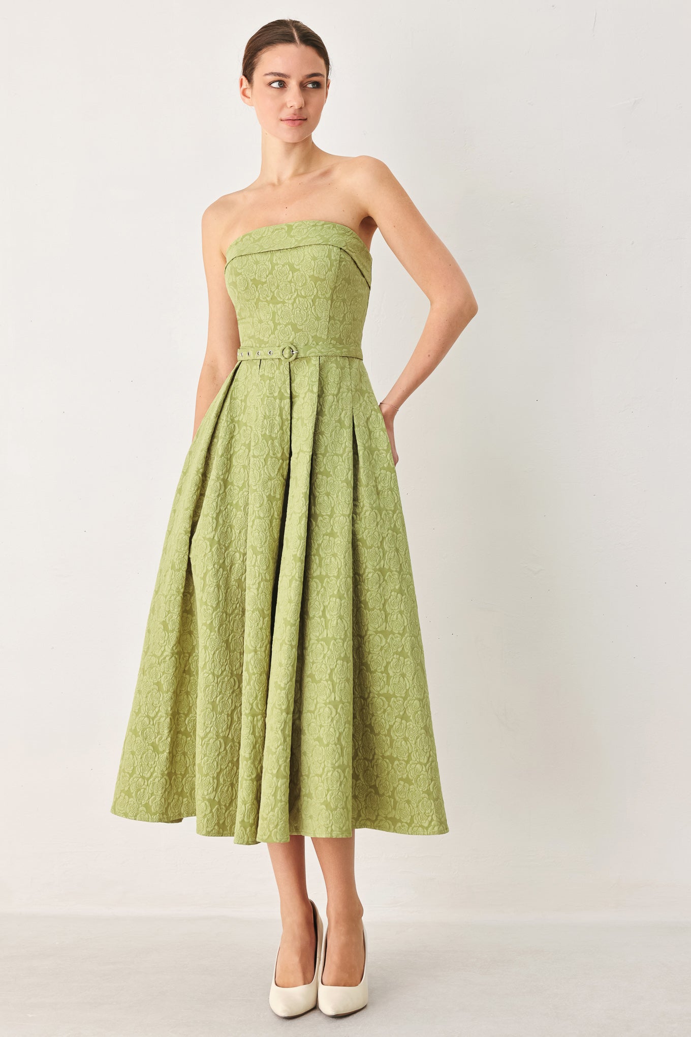 A woman modeling a strapless midi dress in a light olive color with a textured jacquard pattern | FREEMARKET