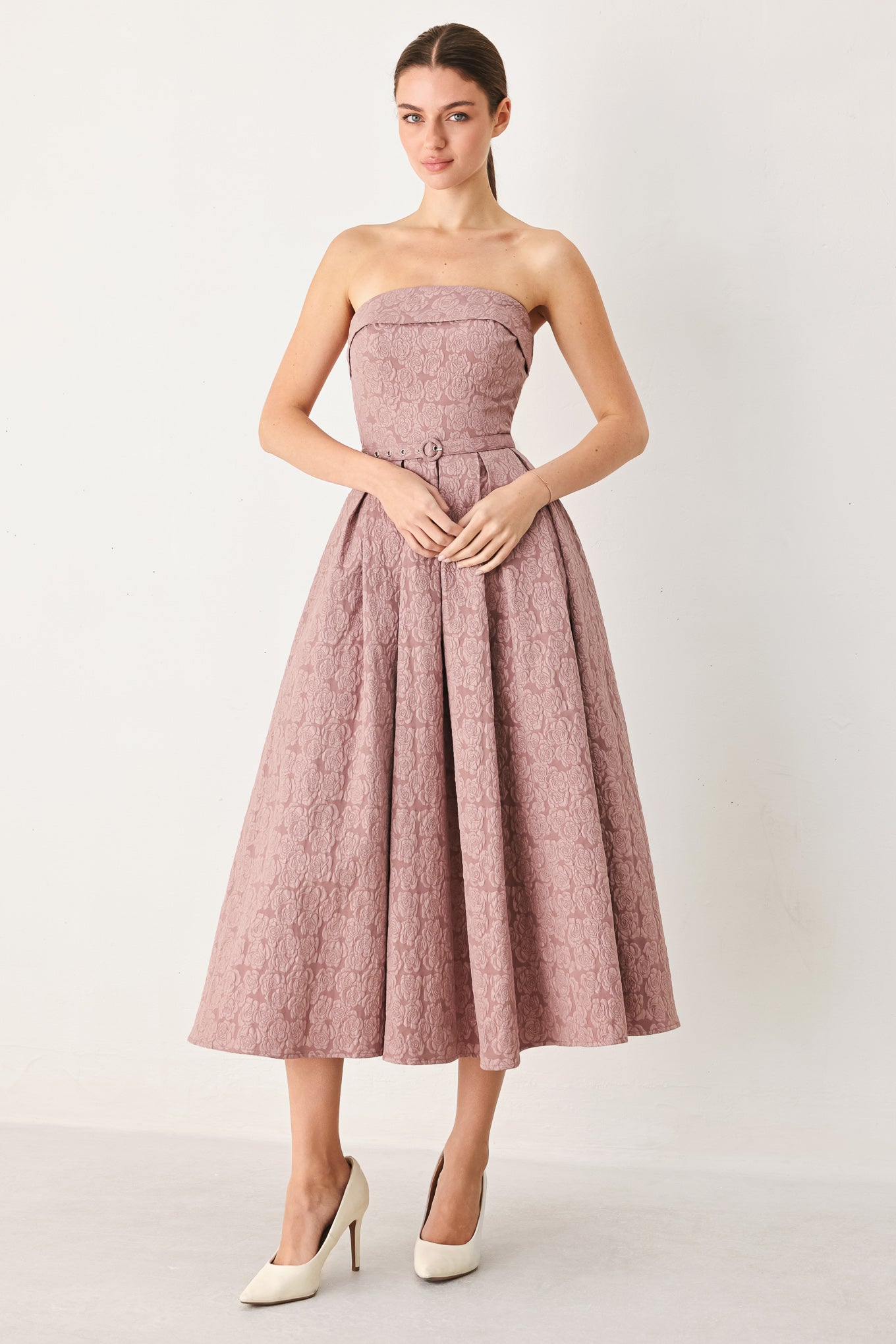 A woman modeling a strapless midi dress in a dusty rose pink color with a textured jacquard pattern | FREEMARKET