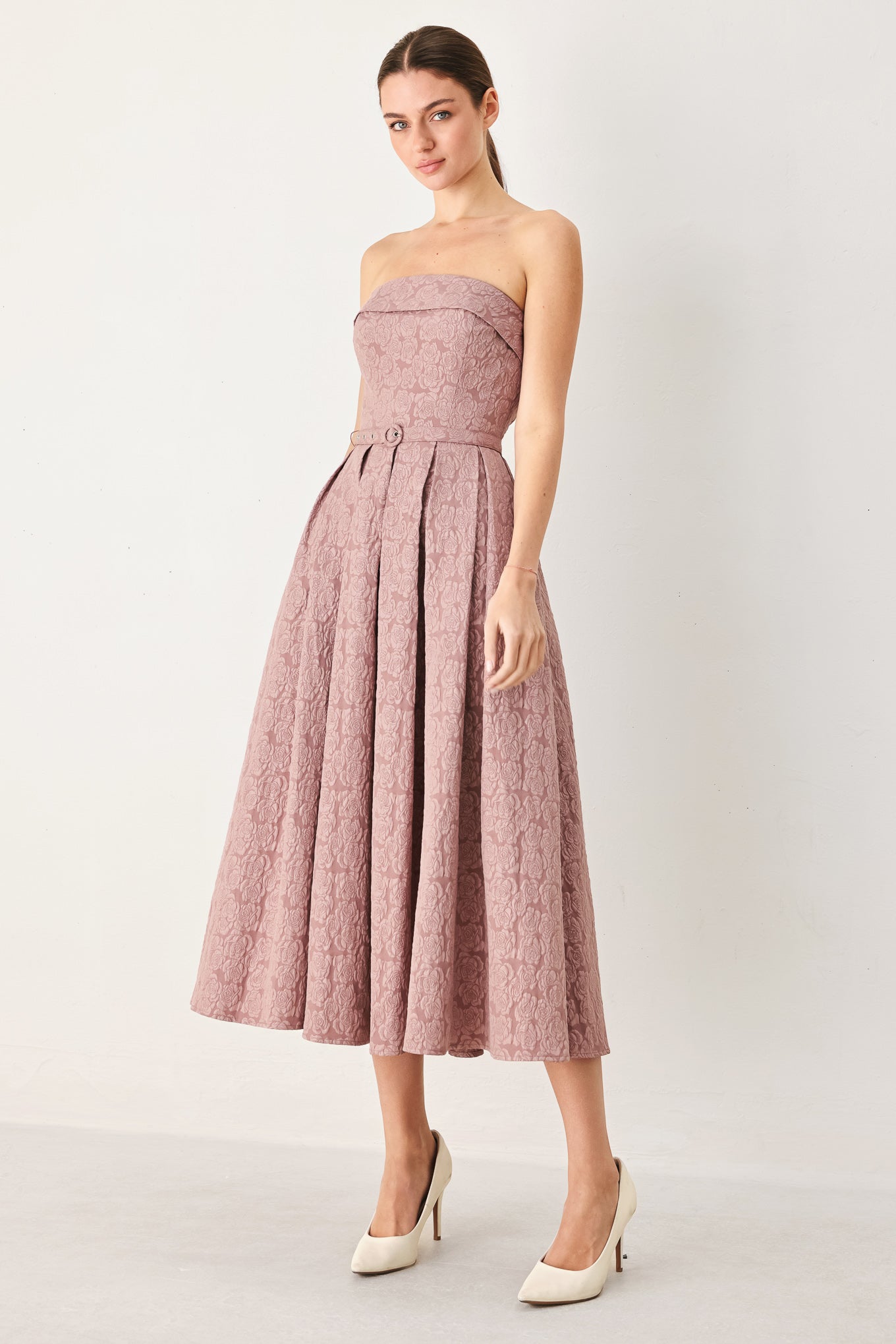 A woman modeling a strapless midi dress in a dusty rose pink color with a textured jacquard pattern | FREEMARKET
