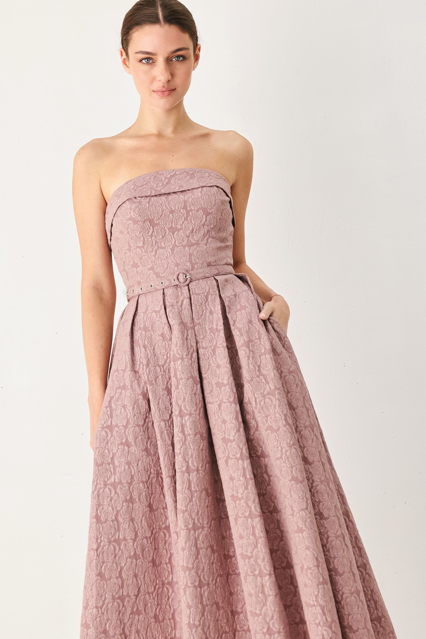 A woman modeling a strapless midi dress in a dusty rose pink color with a textured jacquard pattern | FREEMARKET