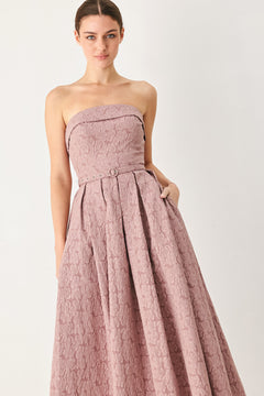 A woman modeling a strapless midi dress in a dusty rose pink color with a textured jacquard pattern | FREEMARKET