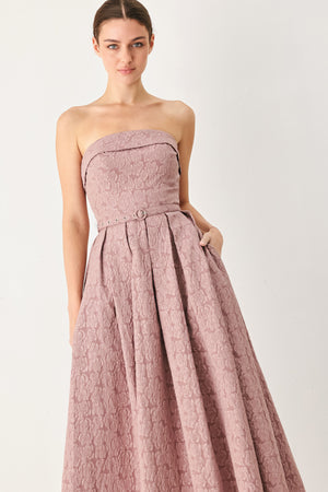A woman modeling a strapless midi dress in a dusty rose pink color with a textured jacquard pattern | FREEMARKET