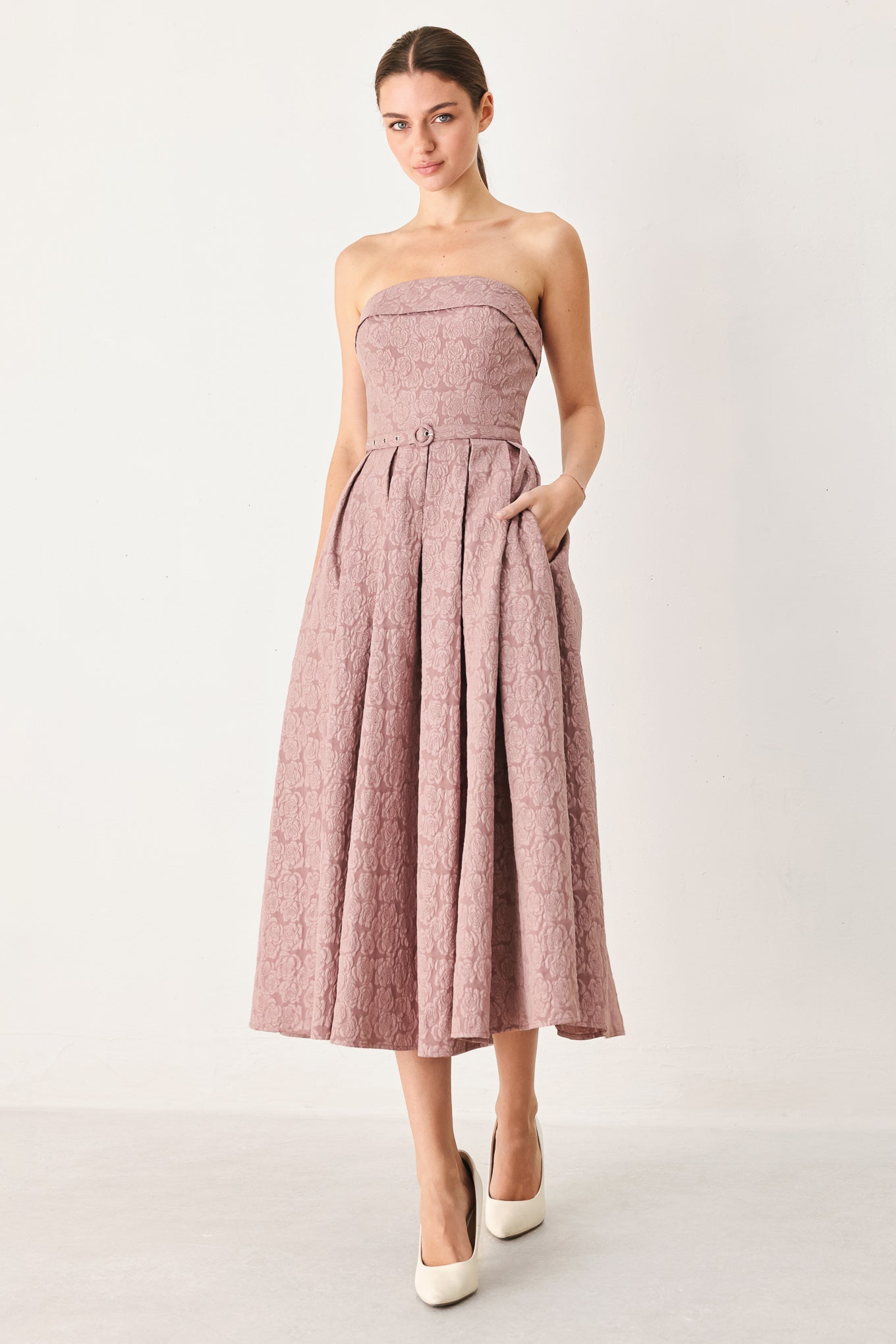 A woman modeling a strapless midi dress in a dusty rose pink color with a textured jacquard pattern | FREEMARKET
