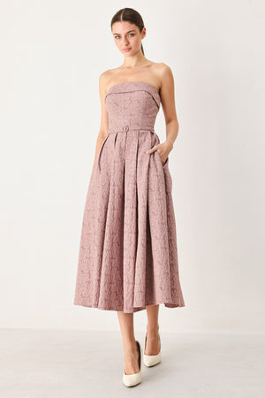 A woman modeling a strapless midi dress in a dusty rose pink color with a textured jacquard pattern | FREEMARKET