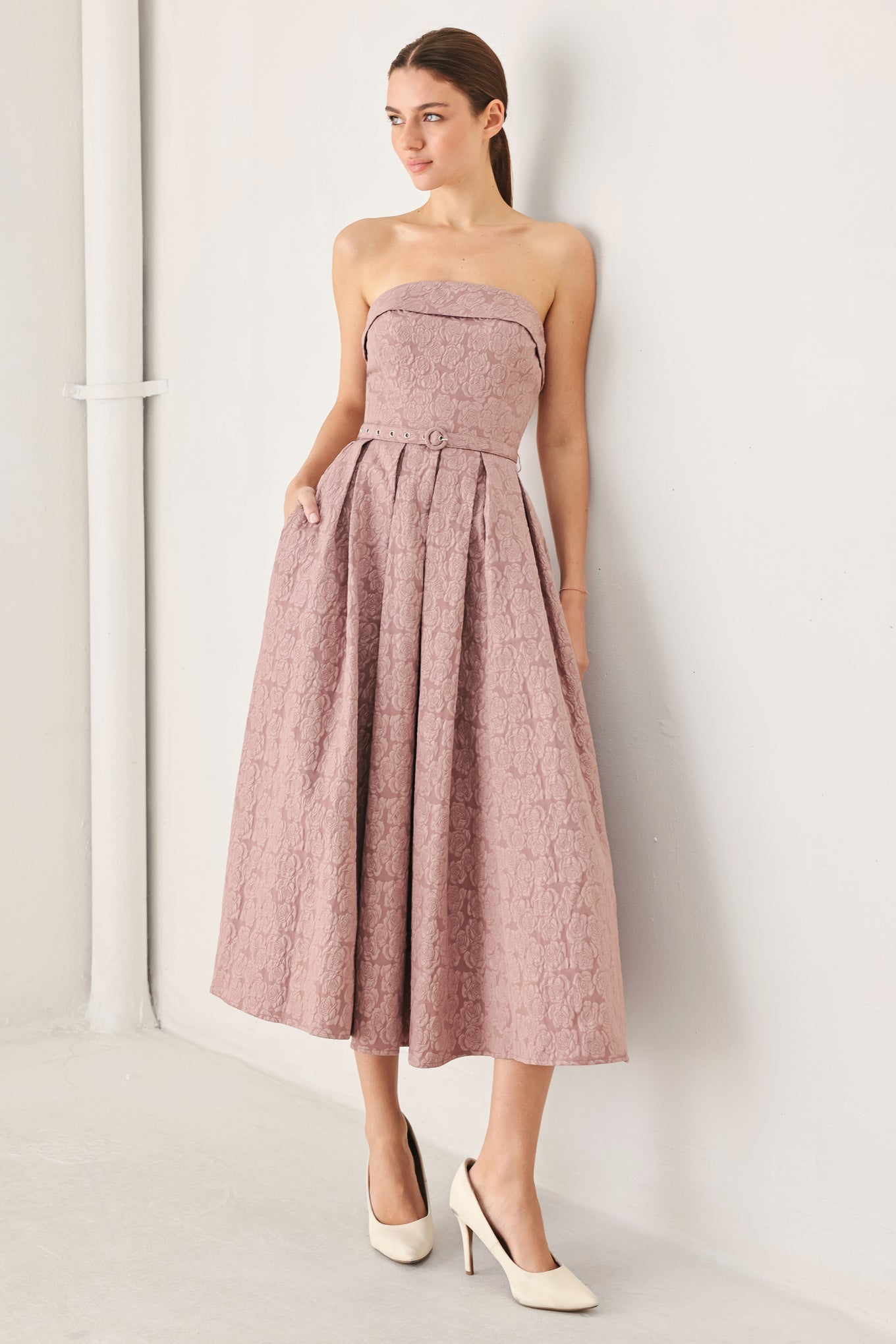 A woman modeling a strapless midi dress in a dusty rose pink color with a textured jacquard pattern | FREEMARKET