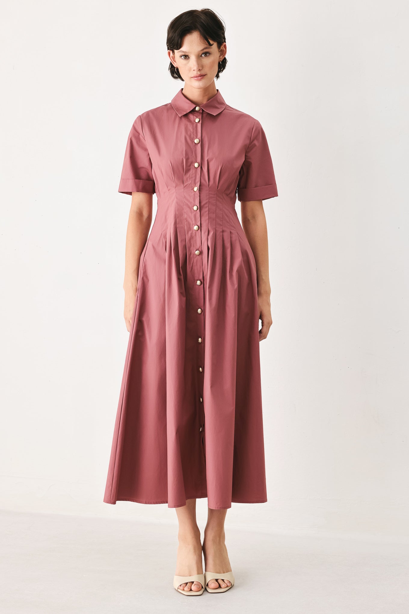 Woman wearing a mauve pink midi dress featuring collar, short sleeve, button down, corset waist, side pockets and full skirt | FREEMARKET