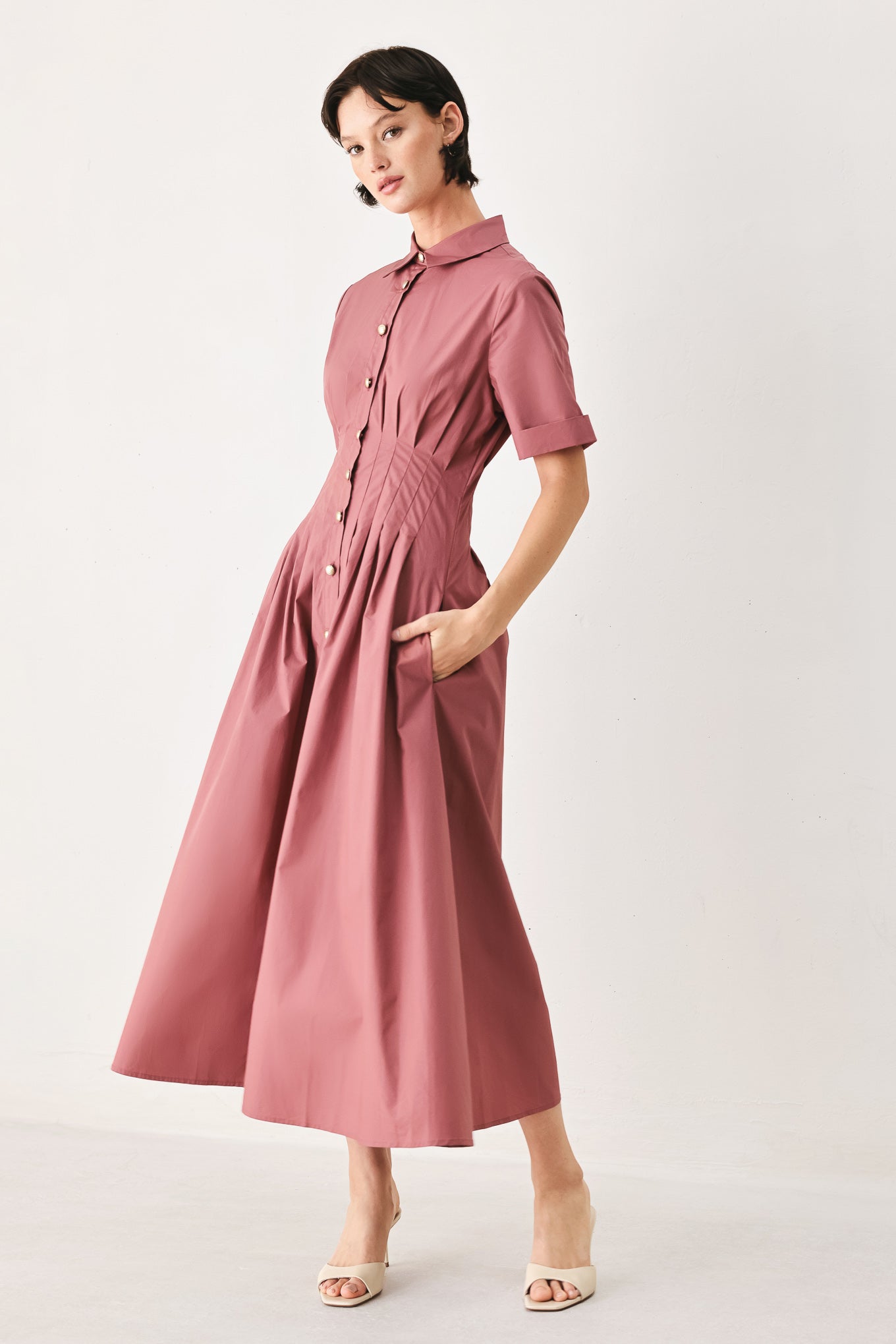 Woman wearing a mauve pink midi dress featuring collar, short sleeve, button down, corset waist, side pockets and full skirt | FREEMARKET