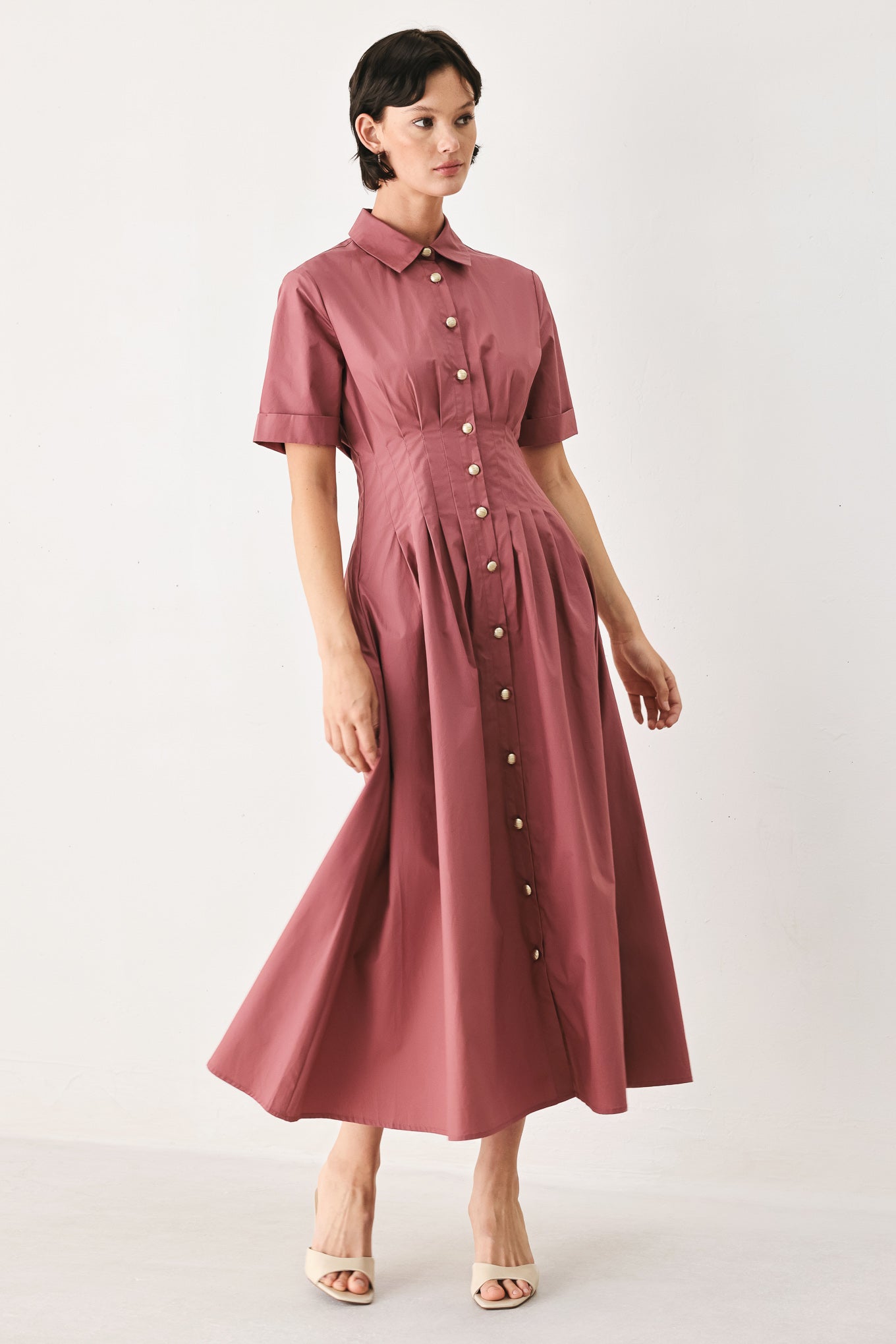 Woman wearing a mauve pink midi dress featuring collar, short sleeve, button down, corset waist, side pockets and full skirt | FREEMARKET