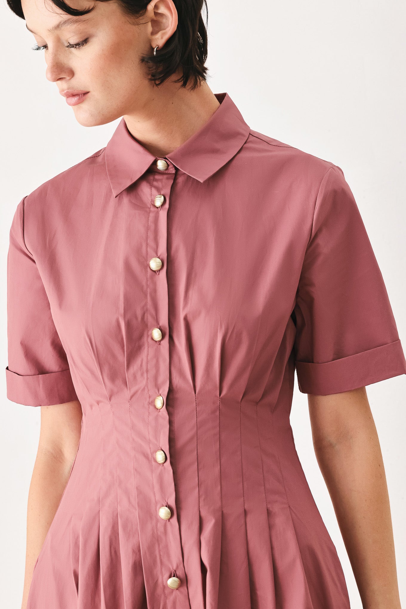 Woman wearing a mauve pink midi dress featuring collar, short sleeve, button down, corset waist, side pockets and full skirt | FREEMARKET