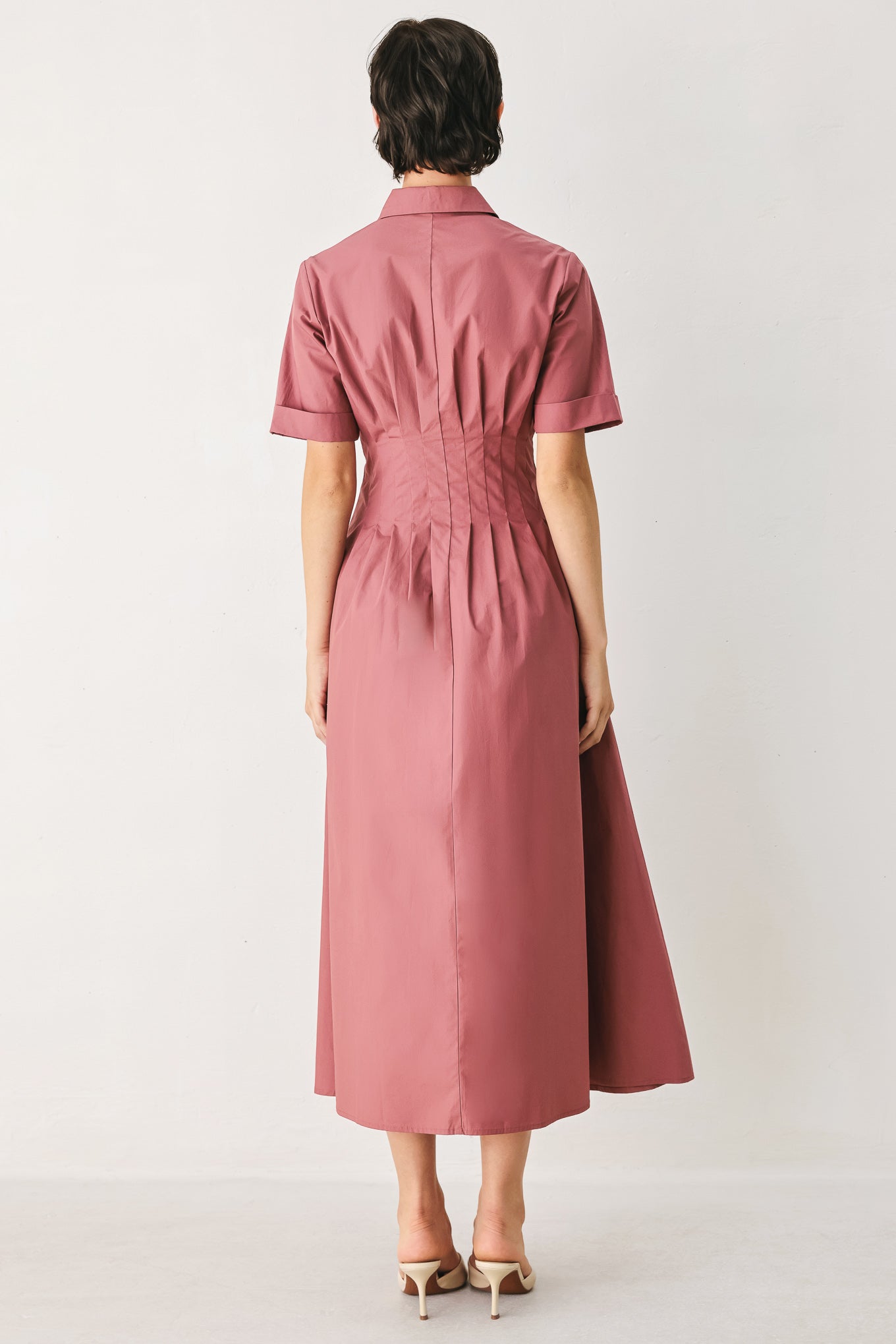 Woman wearing a mauve pink midi dress featuring collar, short sleeve, button down, corset waist, side pockets and full skirt | FREEMARKET
