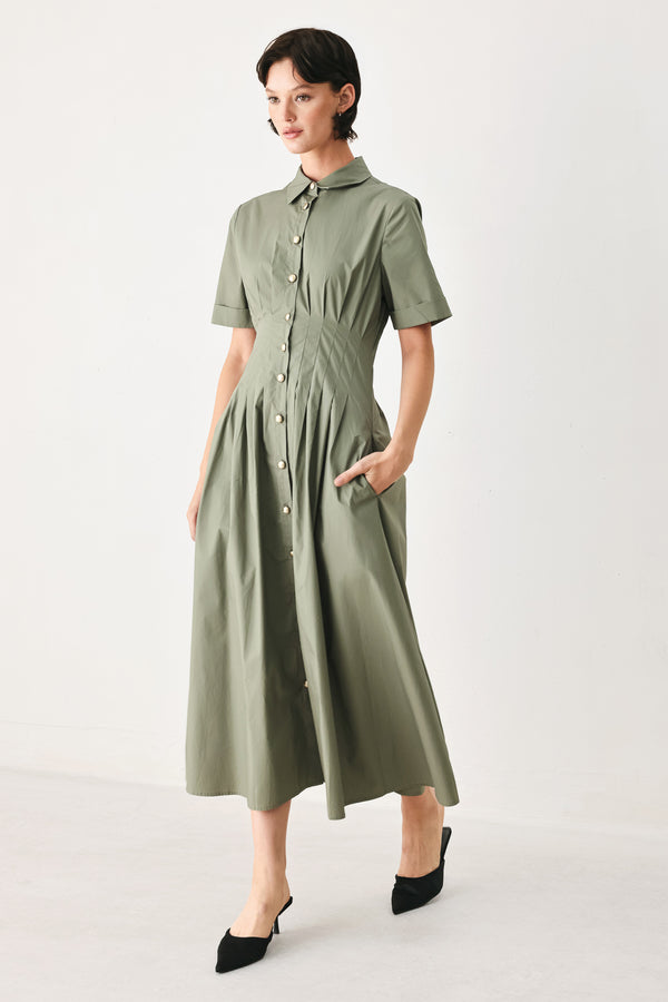 Woman wearing an olive midi dress featuring collar, short sleeve, button down, corset waist, side pockets and full skirt | FREEMARKET