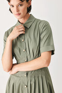 Woman wearing an olive midi dress featuring collar, short sleeve, button down, corset waist, side pockets and full skirt | FREEMARKET