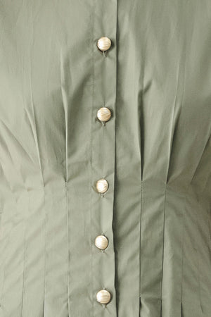 Woman wearing an olive midi dress featuring collar, short sleeve, button down, corset waist, side pockets and full skirt | FREEMARKET