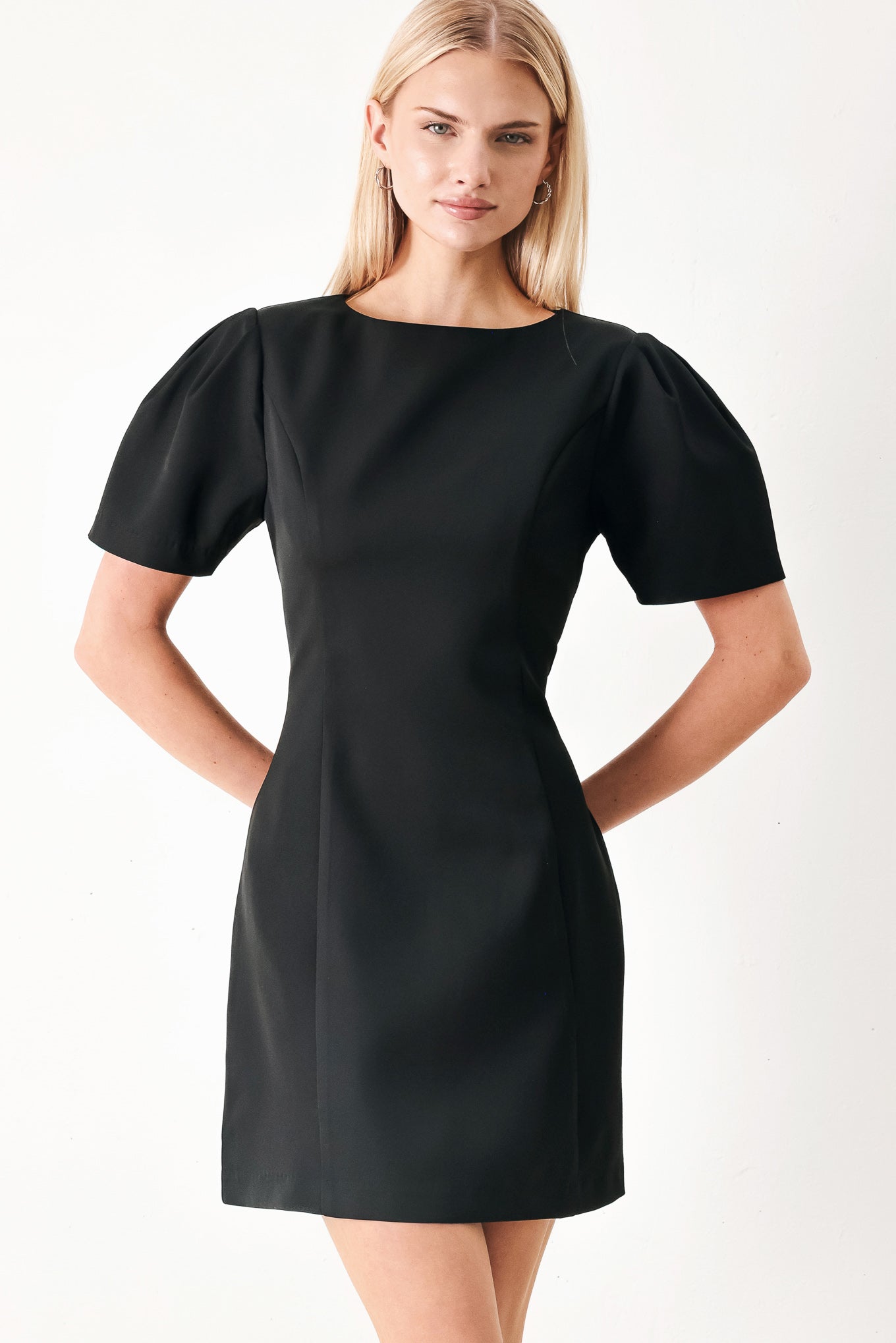 Woman wearing a black mini dress featuring round neckline, short sleeve and back zipper closure | FREEMARKET