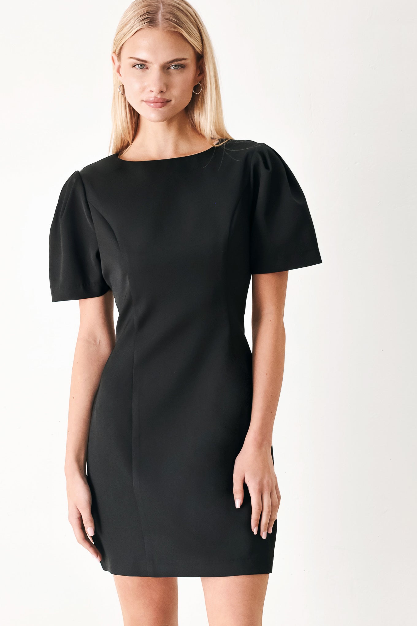 Woman wearing a black mini dress featuring round neckline, short sleeve and back zipper closure | FREEMARKET