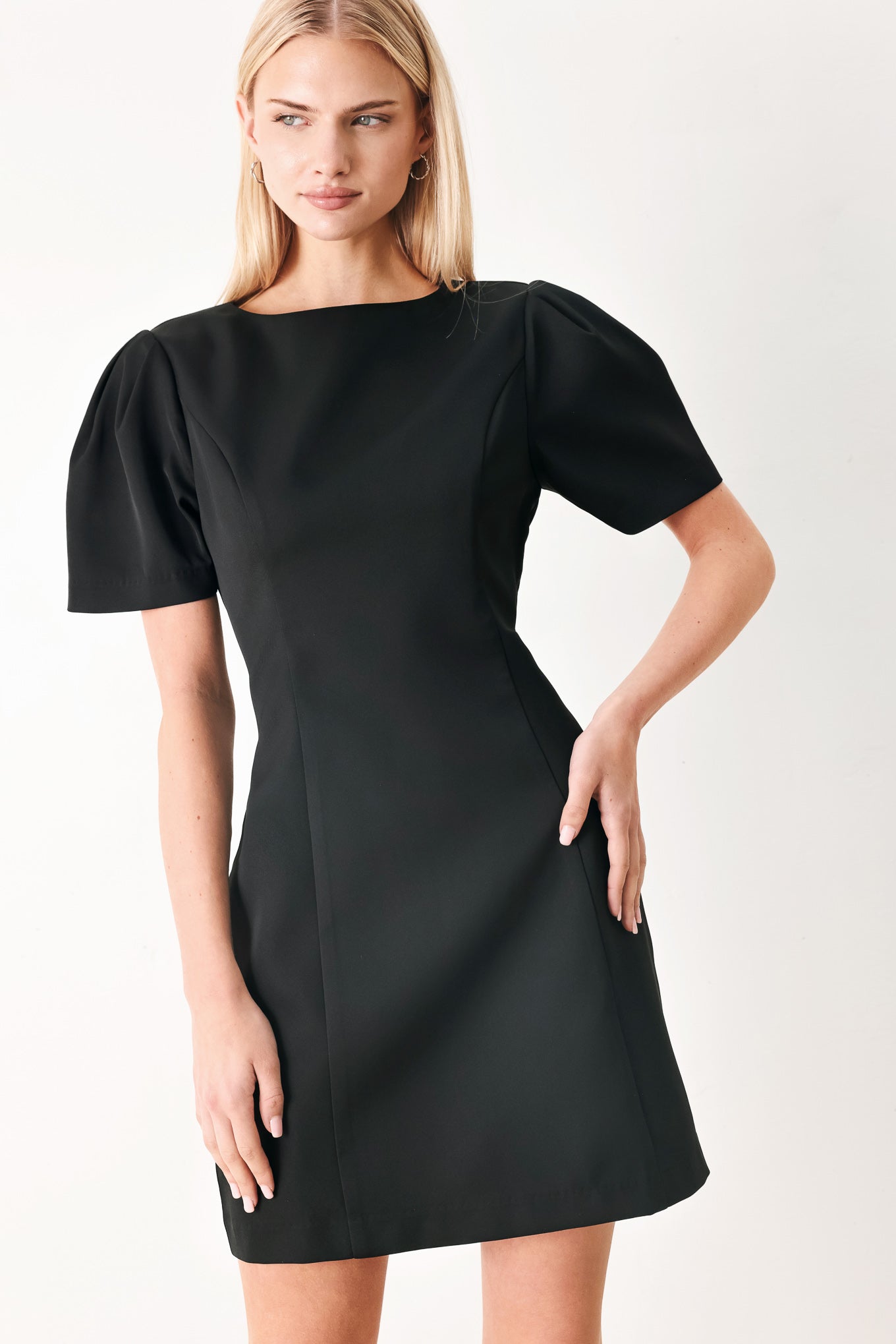 Woman wearing a black mini dress featuring round neckline, short sleeve and back zipper closure | FREEMARKET